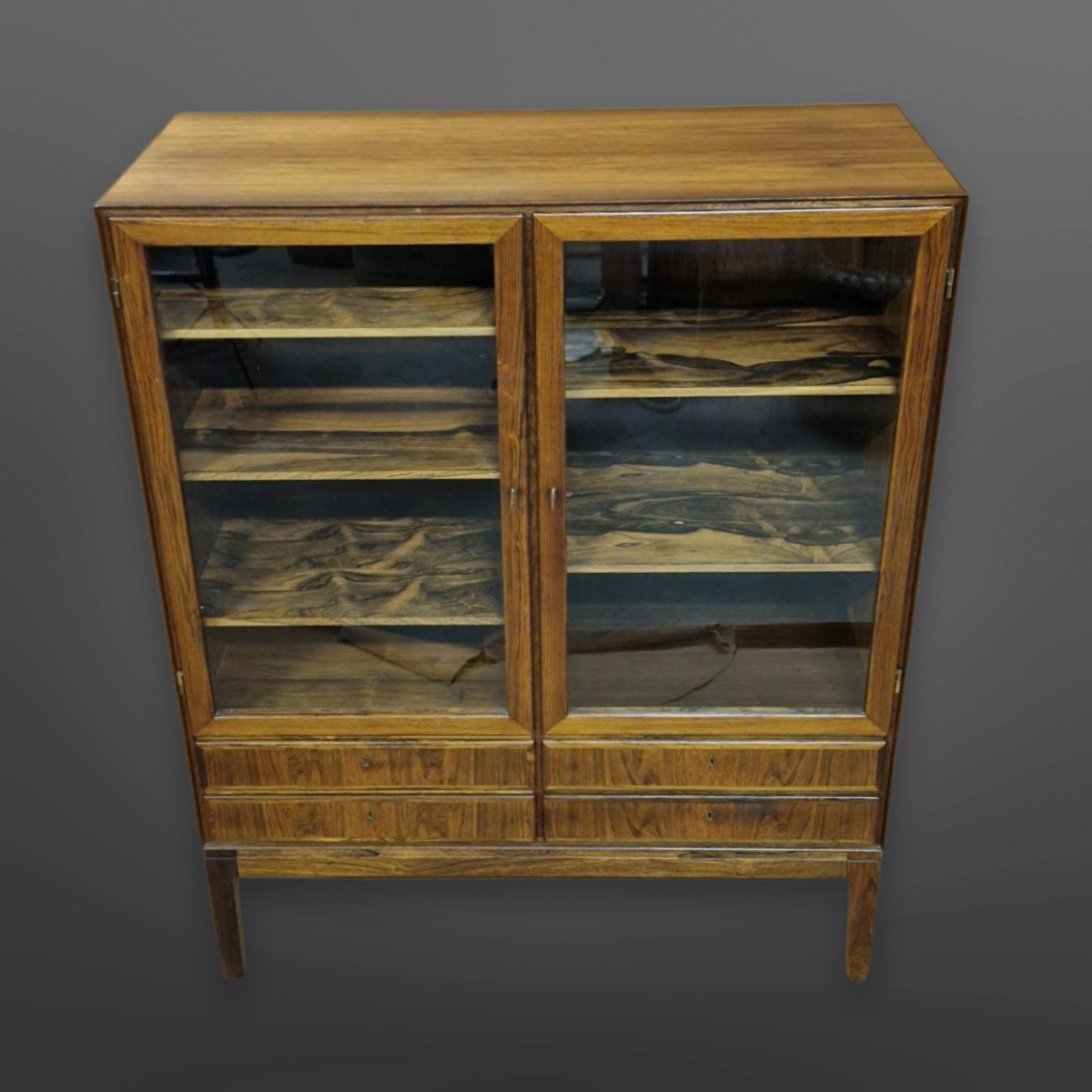 Exclusive high board cabinet in hardwood with 2 doors and 4 drawers. This exceptional piece is part of the Rungstedlund series. Hinges and keys in brass, veneered inside out with beautiful trays. It can be used as room divider due to veneered back.