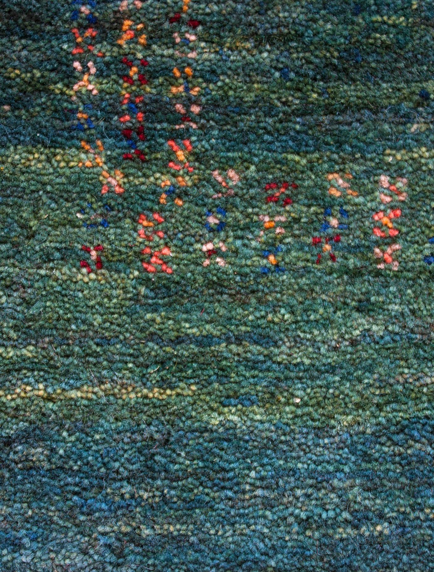 Runner, emerald green contemporary Tribal design Gabbeh Persian wool rug. A field of emerald green bordered with poppies. Hand knotted of 100% organic wool and dyed with all-natural dyes, this rug demonstrates the beauty, durability, and artistic