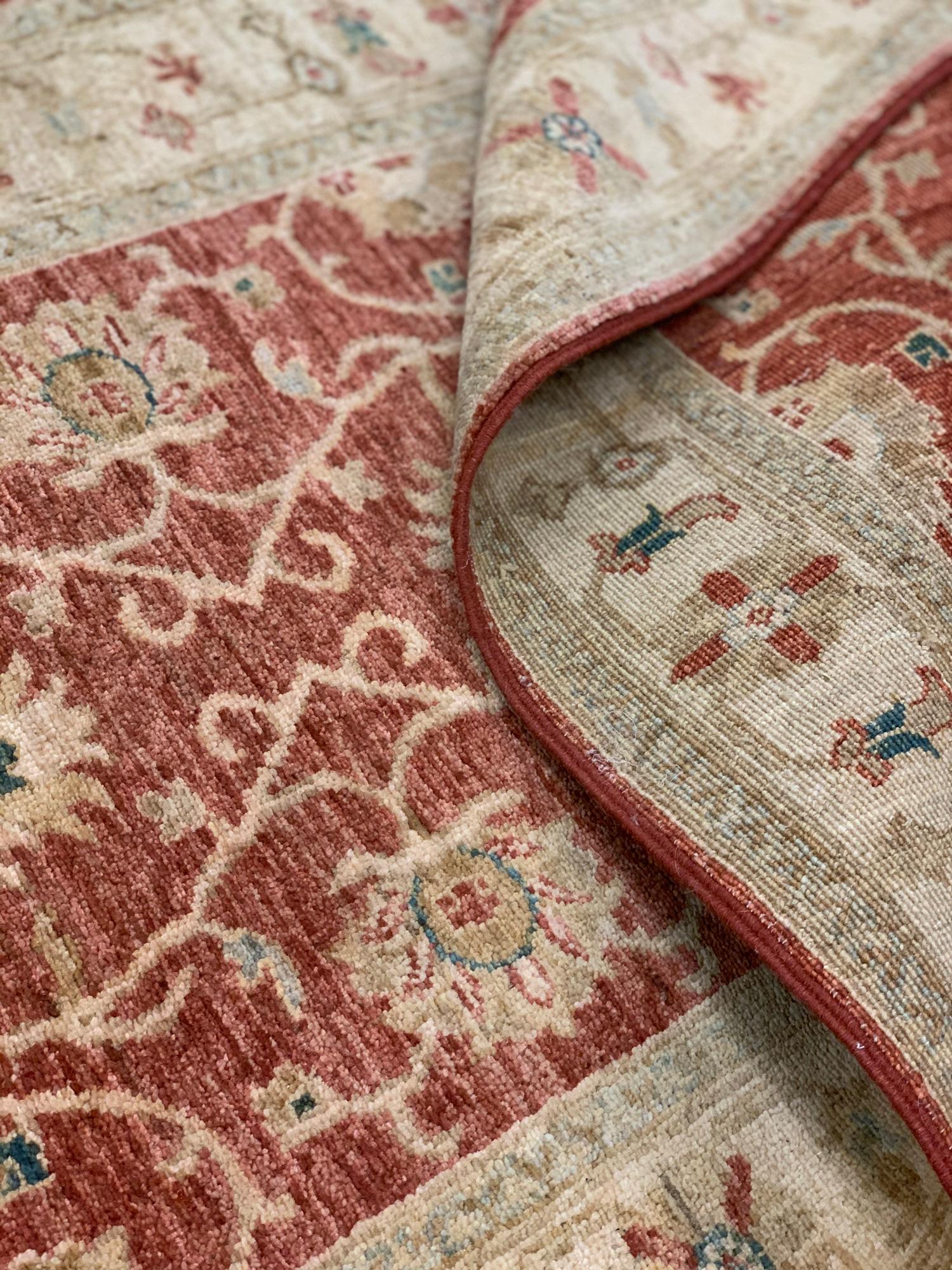 This elegant wool runner rug is a Ziegler runner rug. Woven by hand in the early 21st century, circa 2010. The design features floral patterns traditionally seen in Ziegler carpets and rugs. The rustic colour palette and classic design featured in