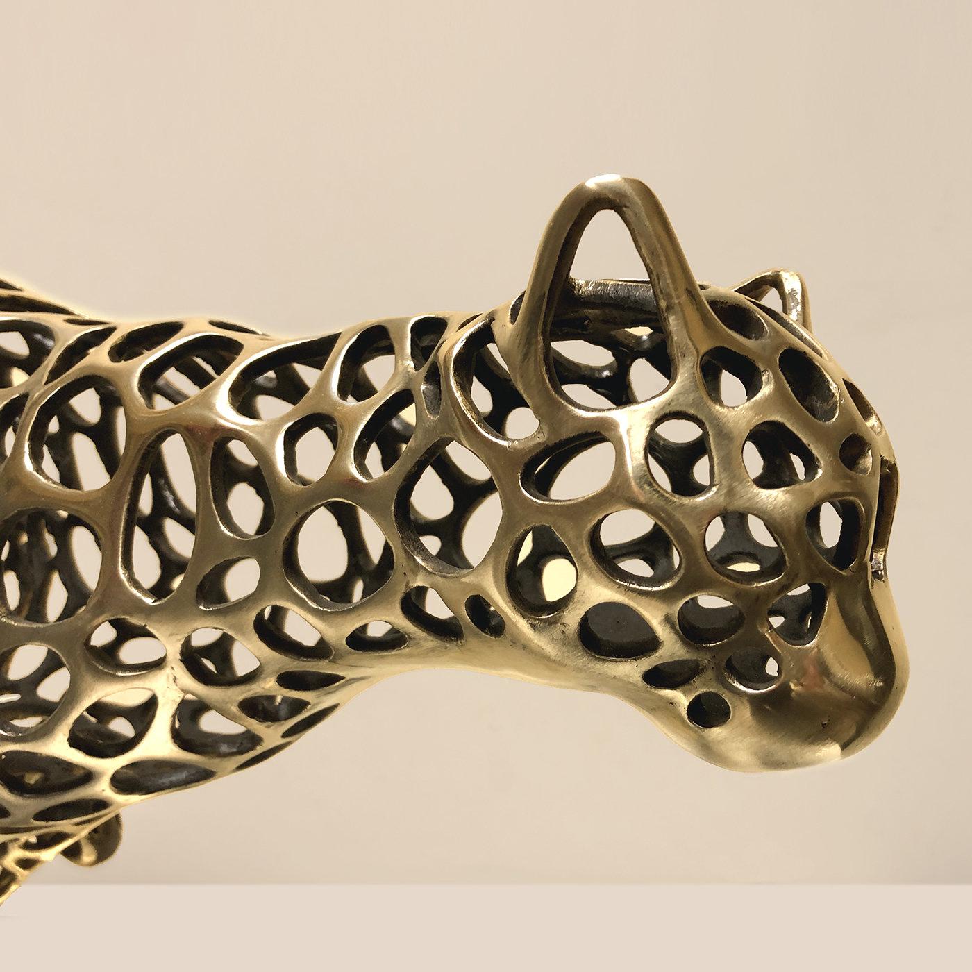 Exuding a fierce character and velocity, this stunning sculpture depicts a running cheetah. Exquisitely crafted of bronze using the lost-wax casting technique, the piece is marked by a series of perforations that add lightness to the sense of