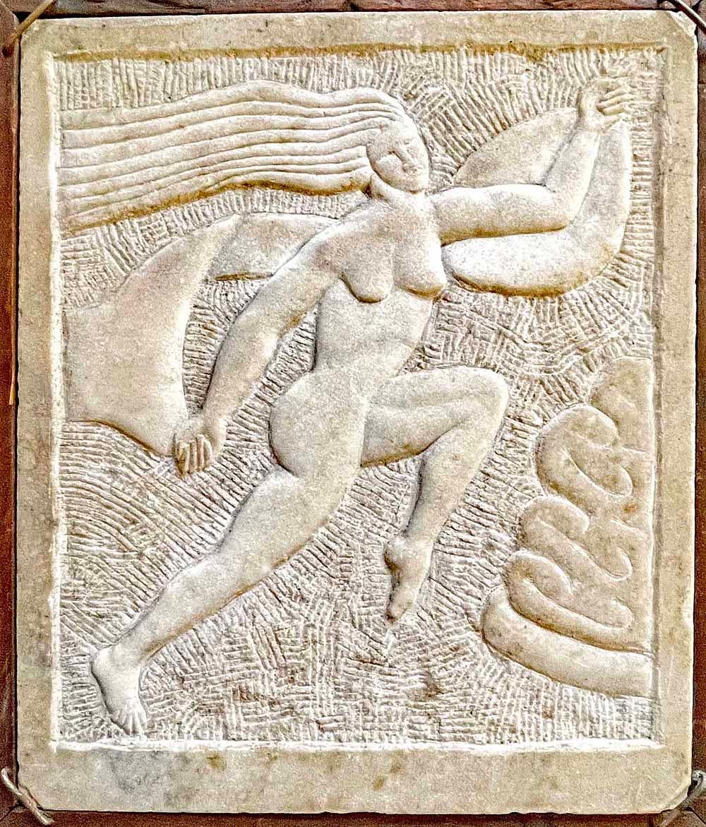 Diese Tafel ist ein fabelhaftes Beispiel für die vom Art déco beeinflusste Volkskunst. Sie zeigt eine rennende Eva, deren Haar im Wind weht, in geschnitztem König-von-Preußen-Marmor, eingefasst in einen Rahmen aus Kiefernholz, der auf allen Seiten