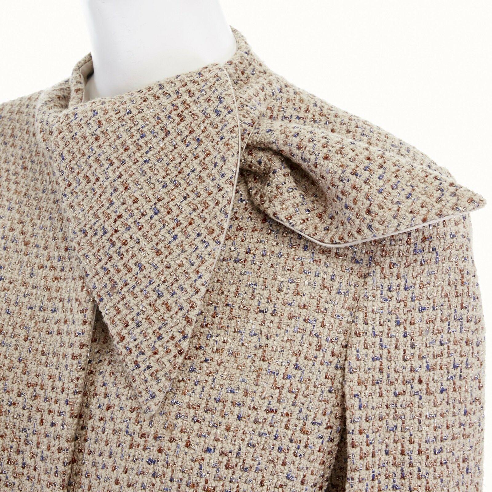 runway ALEXANDER MCQUEEN Vintage AW04 beige boucle tweed tie neck jacket IT42 M
ALEXANDER MCQUEEN
FROM THE FALL WINTER 2004 RUNWAY
Wool, viscose, cotton, silk. 
Light beige with metallic blue and bronze thread boucle tweed outer. 
Mother of pearl