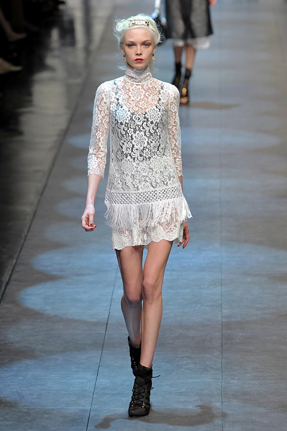 The Runway Dolce & Gabbana SS 2010 lace top with fringes is a beautiful and stylish piece. It features delicate lace fabric with a floral pattern and fringes that add a playful touch. It's a size 42IT or M, and it's in very good condition. Perfect