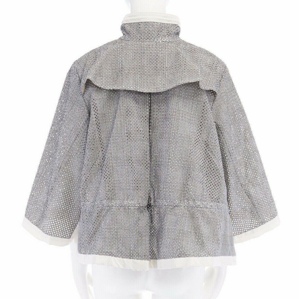 runway SACAI SS14 grey prince of wales perforated flared back swing jacket JP1
SACAI BY CHITOSE ABE
FROM THE SPRING SUMMER 2014 COLLECTION
Cotton, polyester, cupro. Grey Prince of Wales checked. 
Perforated holes along sleeve and hem. High collar.