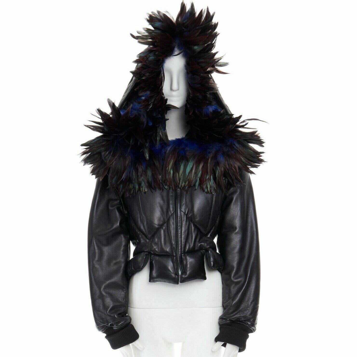 YOHJI YAMAMOTO
FROM THE FALL WINTER 2005 RUNWAY
Leather and feather • Black padded jacket • Cropped fit • Extremely oversized hood trimmed with blue bird feathers • Zip front closure with silver Riri zip pull • Fitted at waist with peplum panels •
