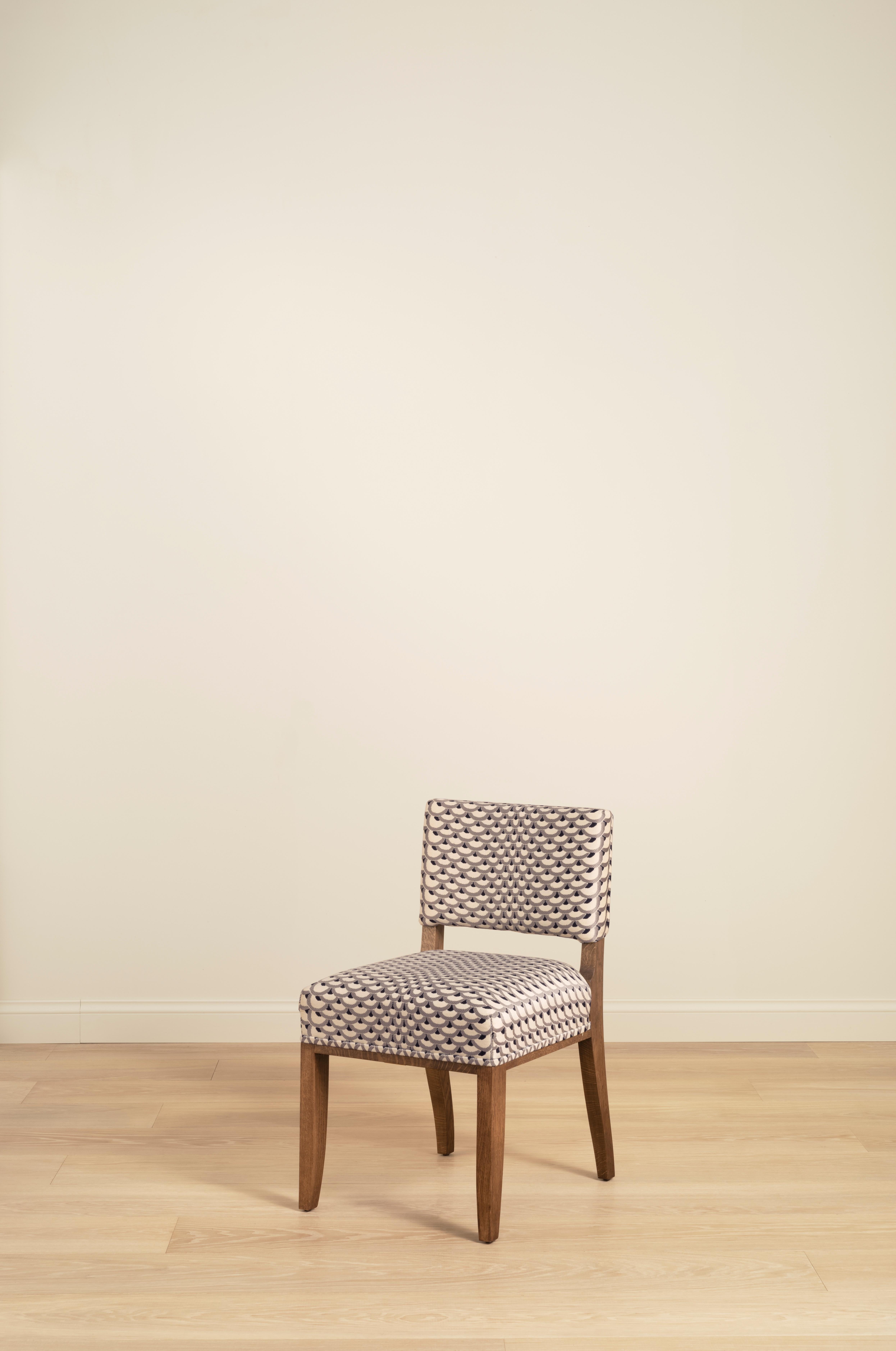 Una sedia da pranzo in stile anni '40, dal design semplice e pulito. 

Seduta e schienale imbottiti in tessuto o pelle a scelta del cliente. Requisiti: 1,75 mq di tessuto o 19 mq di pelle.