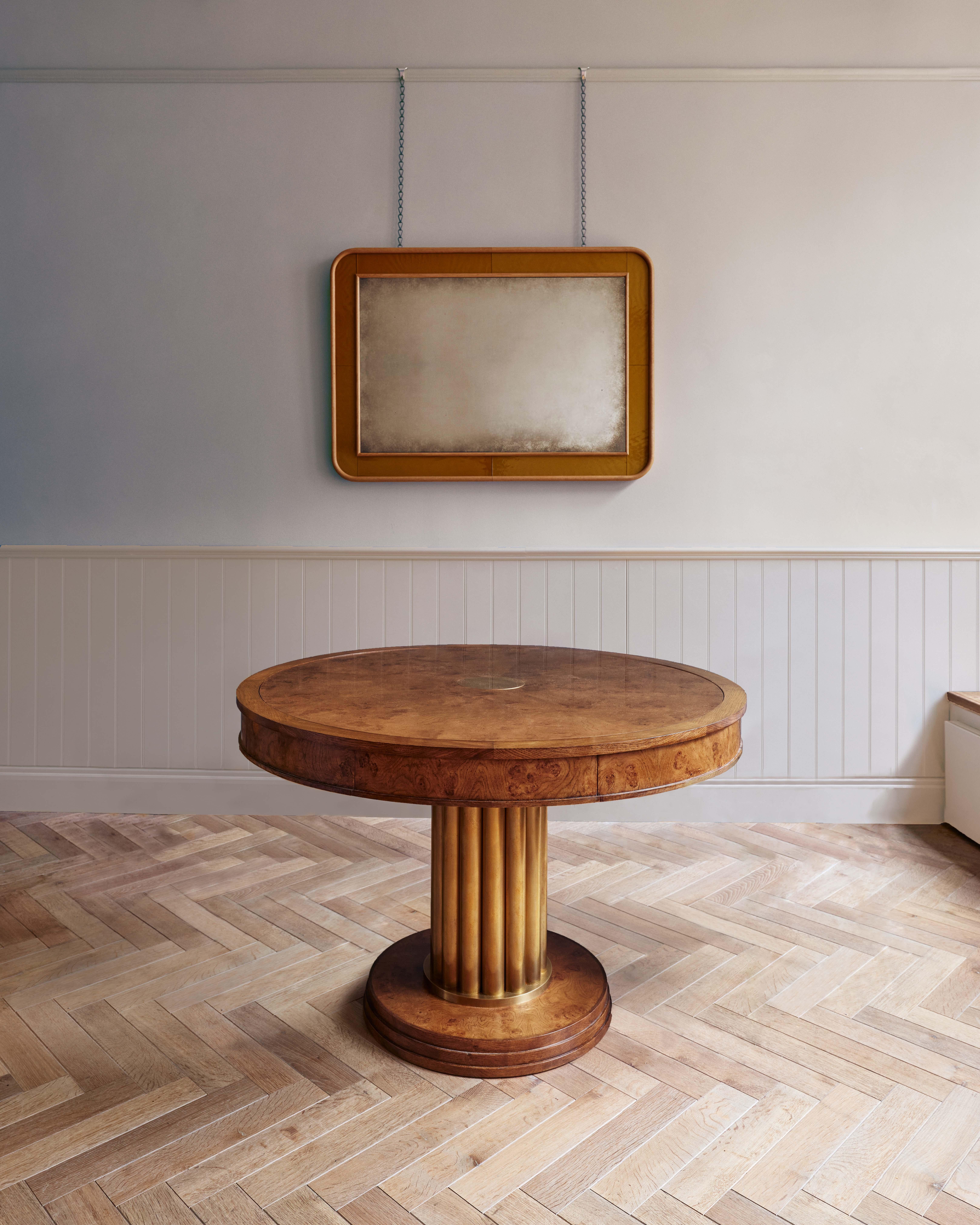 The Dani Games Table is a refined games table crafted from burr oak with a brass-wrapped pedestal. Featuring a reversible alcanatara-covered table top and housing chess pieces, backgammon and poker in drawers concealed within the apron of the table.