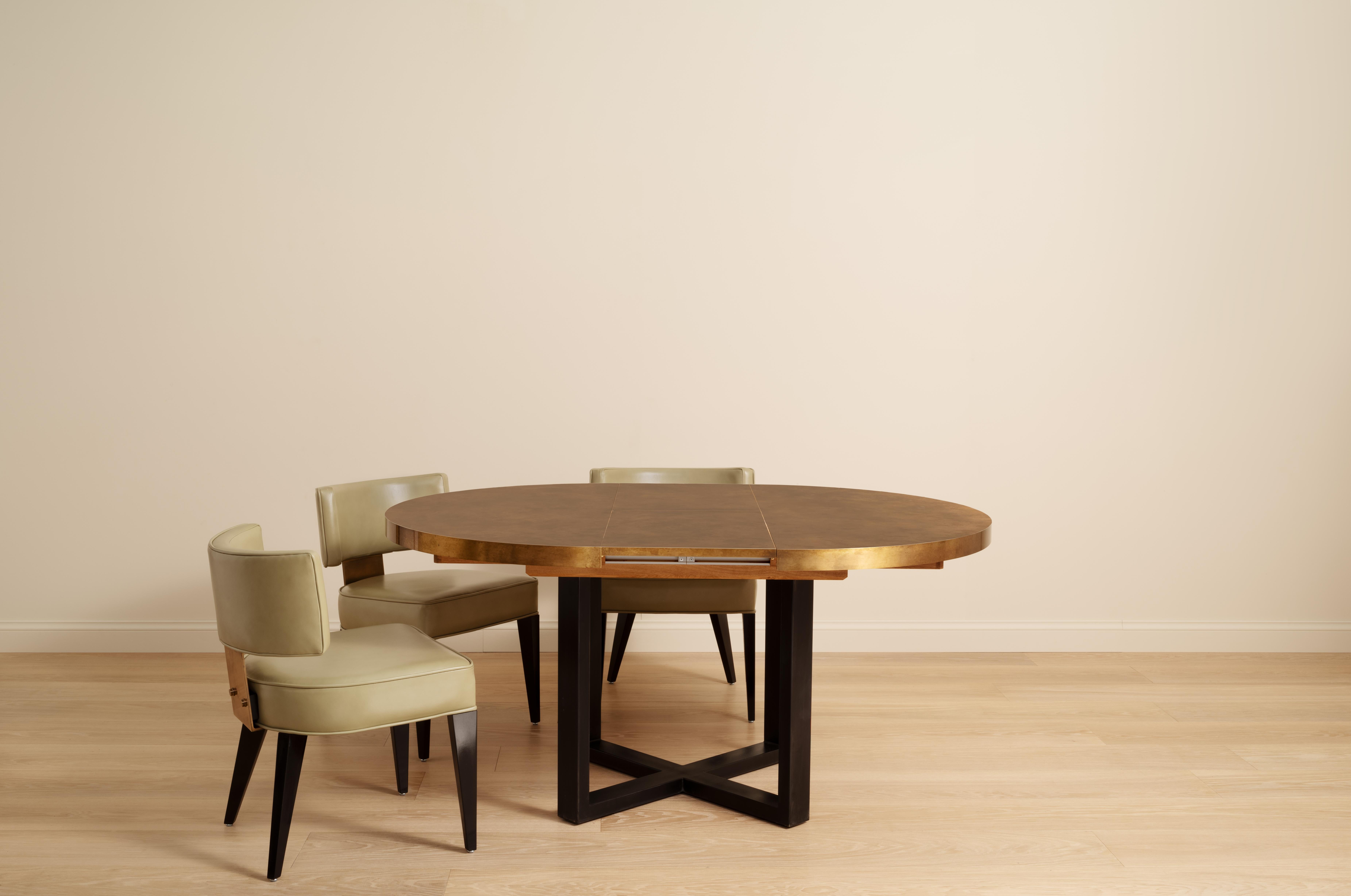 The Orlando Extending Brass Dining Table features a brass wrapped table top with a 'x' frame steel base, available in a powder-coated or blackened steel finish. 

Created to accommodate different and diverse spaces, the Orlando stores a folding leaf