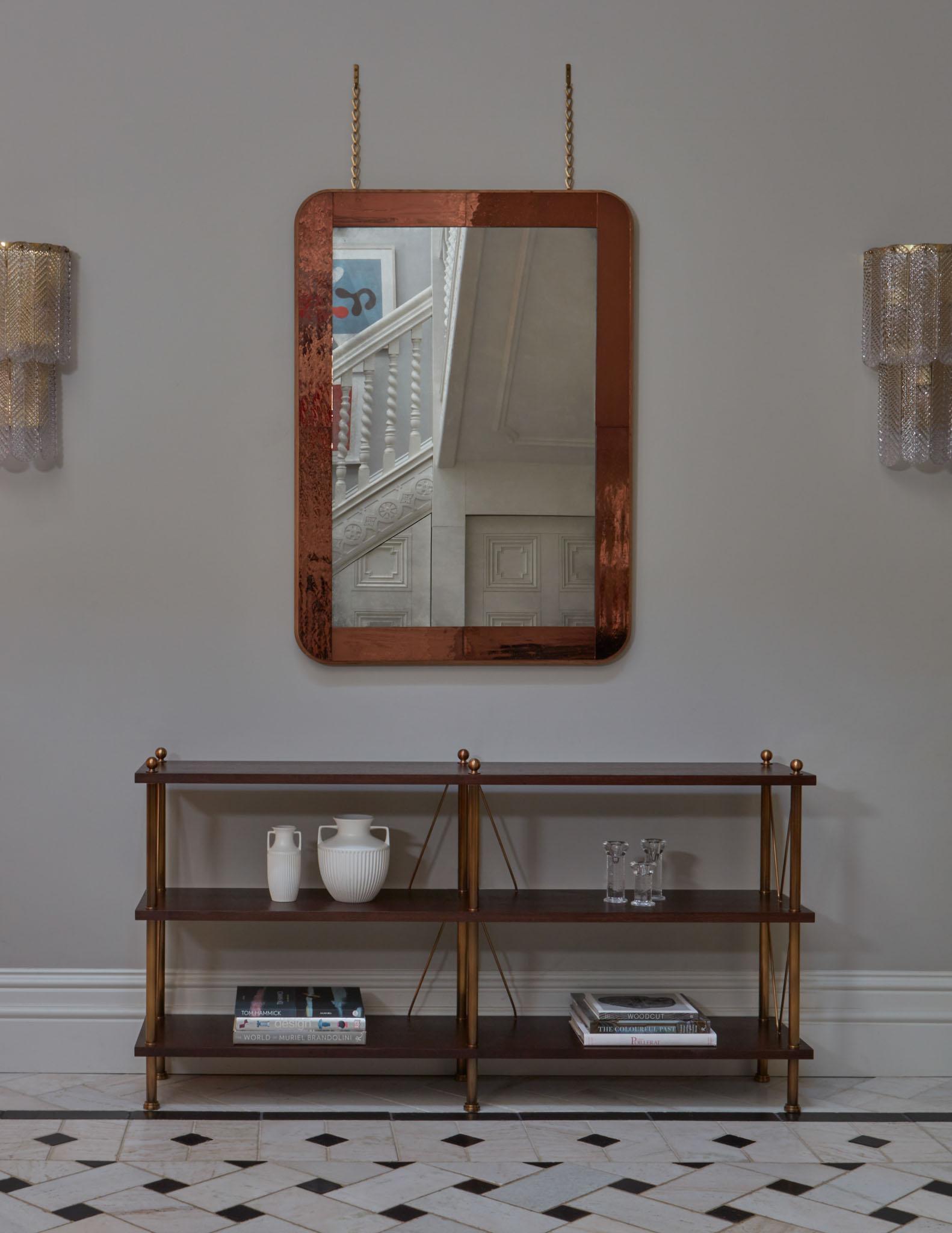 A console table with either stained walnut or leather wrapped shelves, and patinated brass uprights, finials and cross frames.