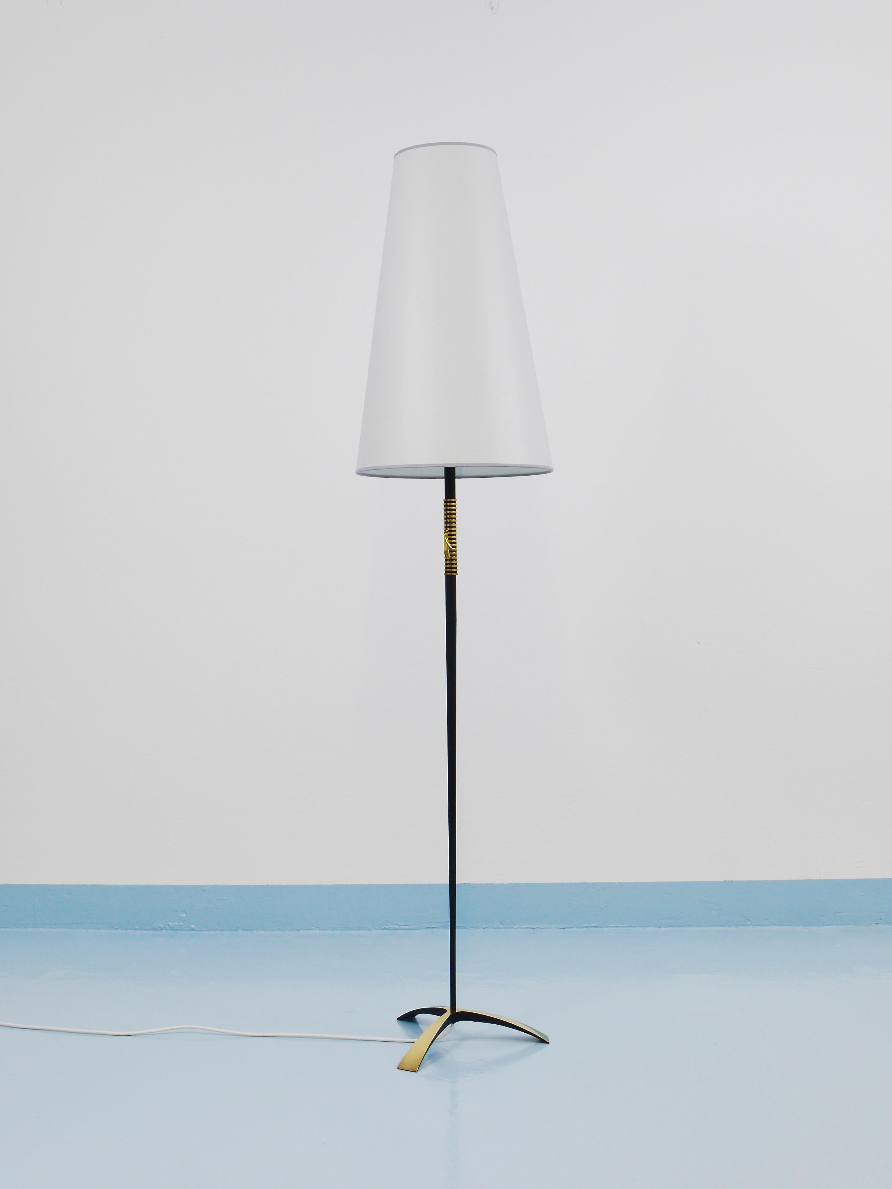 A black and golden mid-century modern floor lamp from the 1950s by Rupert Nikoll, Vienna, Austria. This floor lamp impresses with its elegant and sleek form, which is why it is also referred to as the Spear or Javelin lamp. It features a beautifully