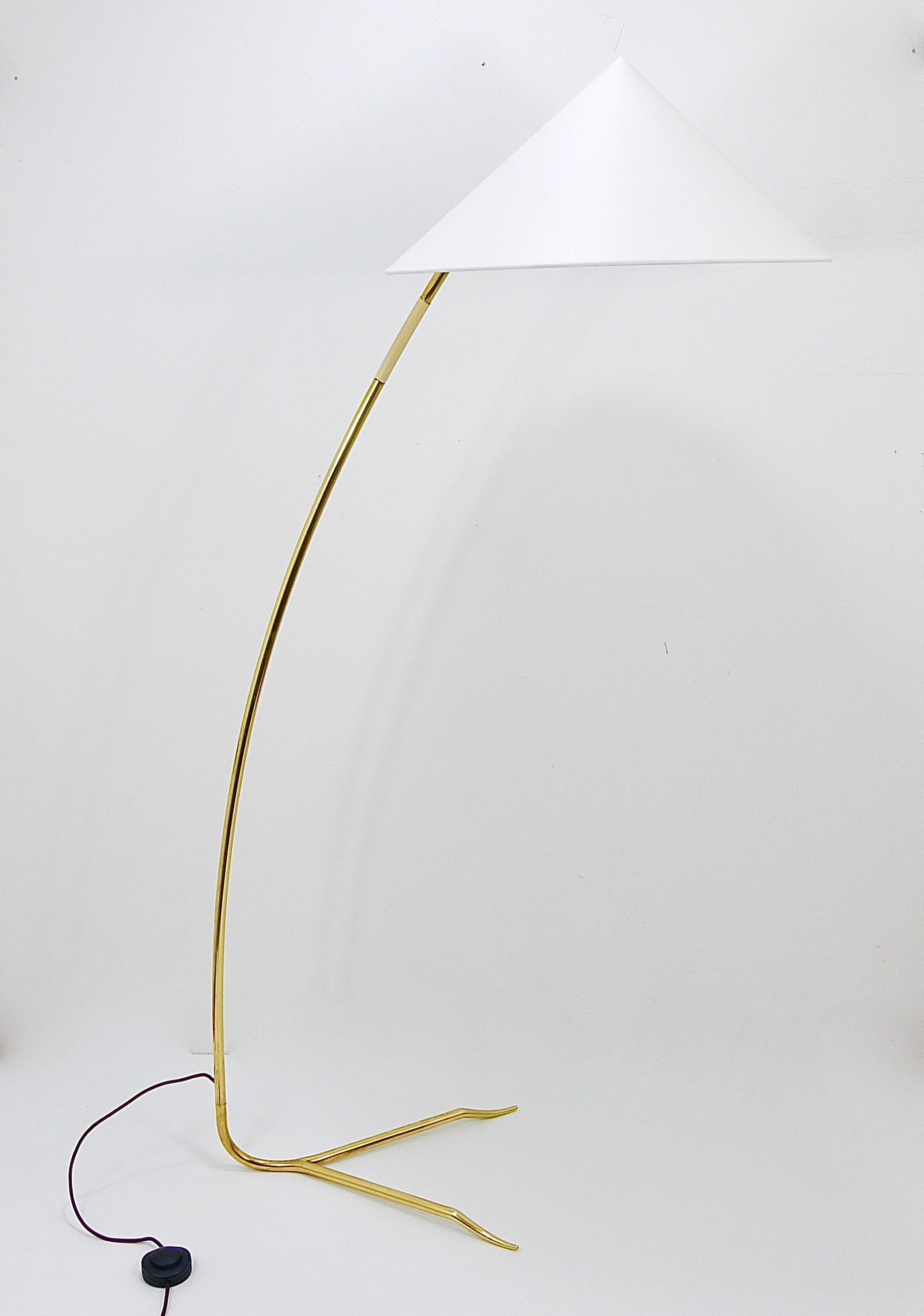 An elegant and exquisite Austrian Mid-Century floor lamp dating back to the 1950s, designed and crafted by Rupert Nikoll Vienna. This beautiful vintage piece features a gracefully curved brass brass stem with an ivory handle and an exceptionally