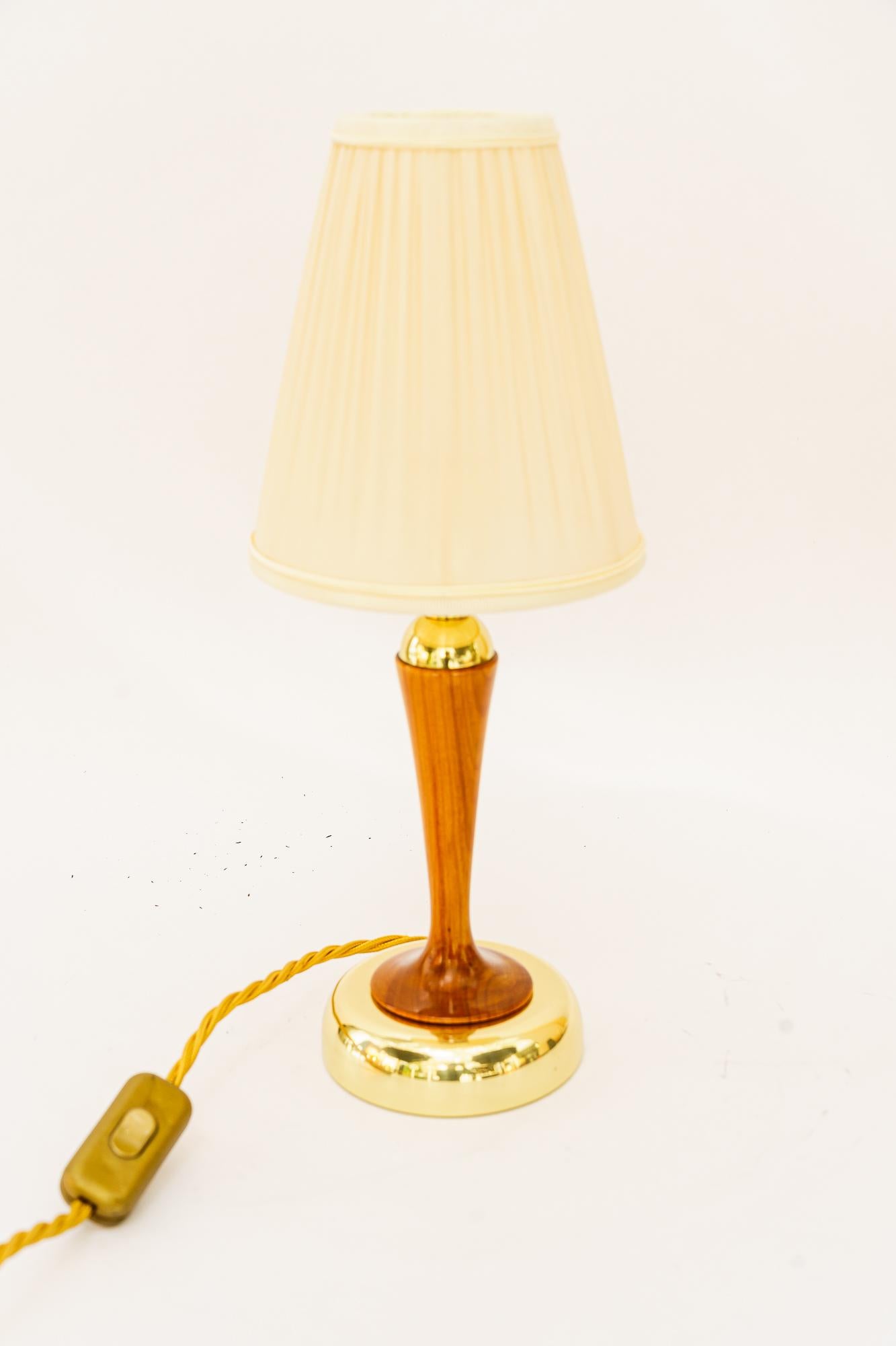Rupert Nikoll Tischlampe mit Kirschholz und Stoffschirm wien um 1950er
Messing poliert und emailliert
Kirschenholz poliert 
Der Stoffschirm wird ersetzt (Neu)
