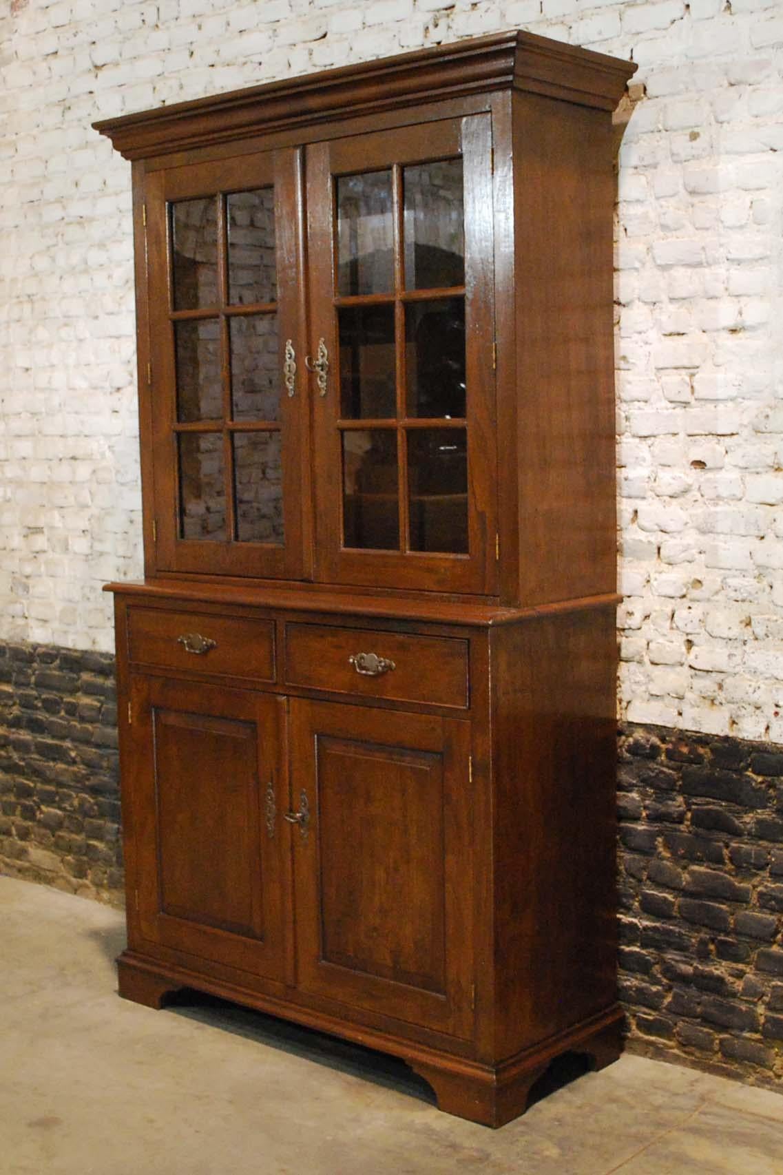 This elegant display cabinet has a Classic shape also known as “Armoire a deux corps”.
The lower cabinet is 4 inches deeper than the upper cabinet. It features two glass doors with six panes each in the upper cabinet. The two shelves in the upper