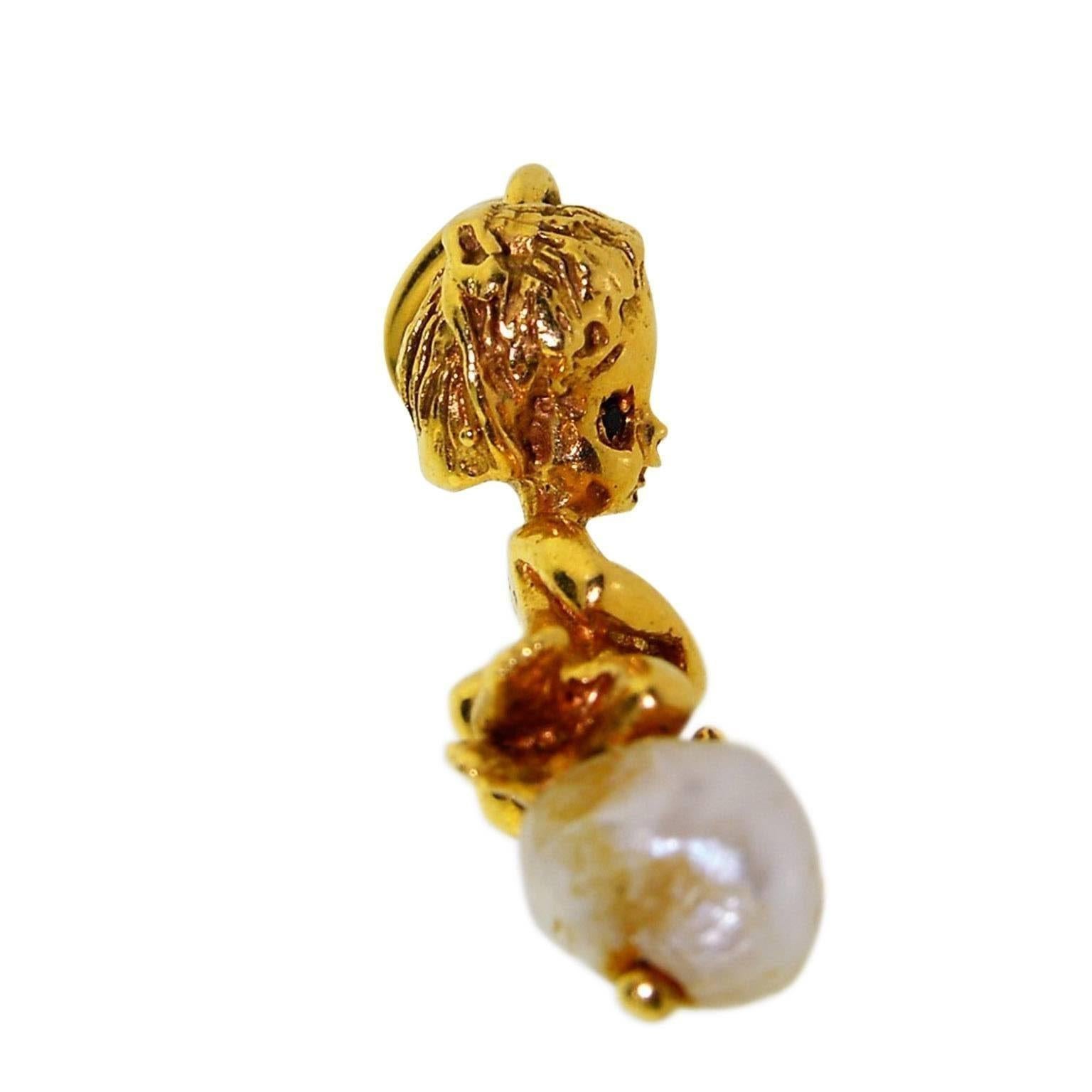 This charming little drop with a natural pearl is done in 14kt solid gold. The eyes are set with sapphires and the little Cherub is holding a broom.
I guess he is cleaning in heaven, or maybe he is practicing for Olympic Curling with a broom.
Bill
