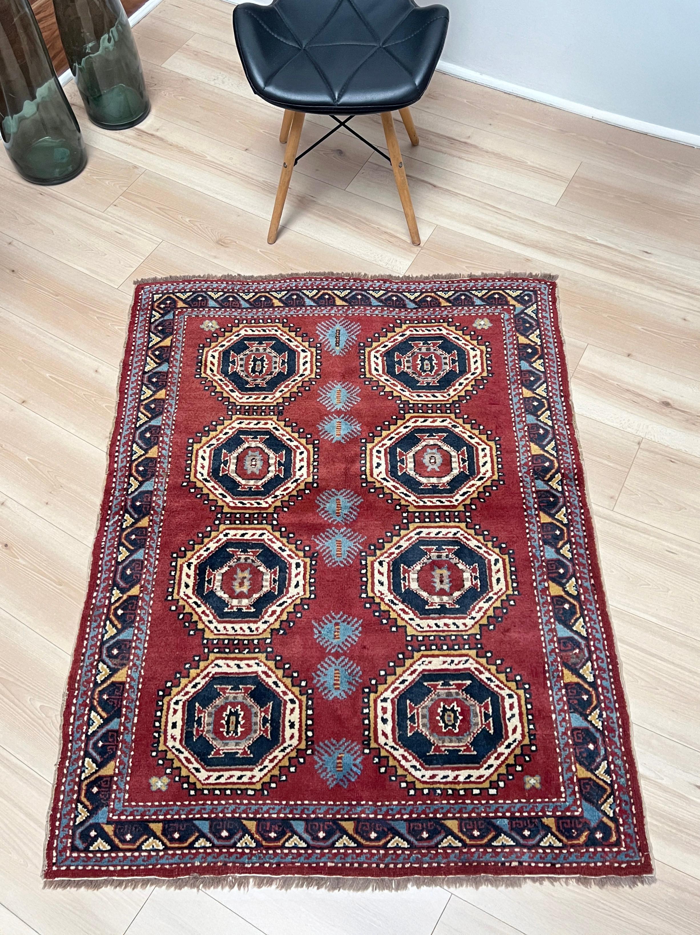 Questo tappeto Derbend vintage del Caucaso emana carattere e calore in un formato compatto e da collezione. Annodato a mano in Azerbaigian negli anni Sessanta, presenta una catena ritmica di medaglioni ottagonali delineati in blu navy e avorio, su