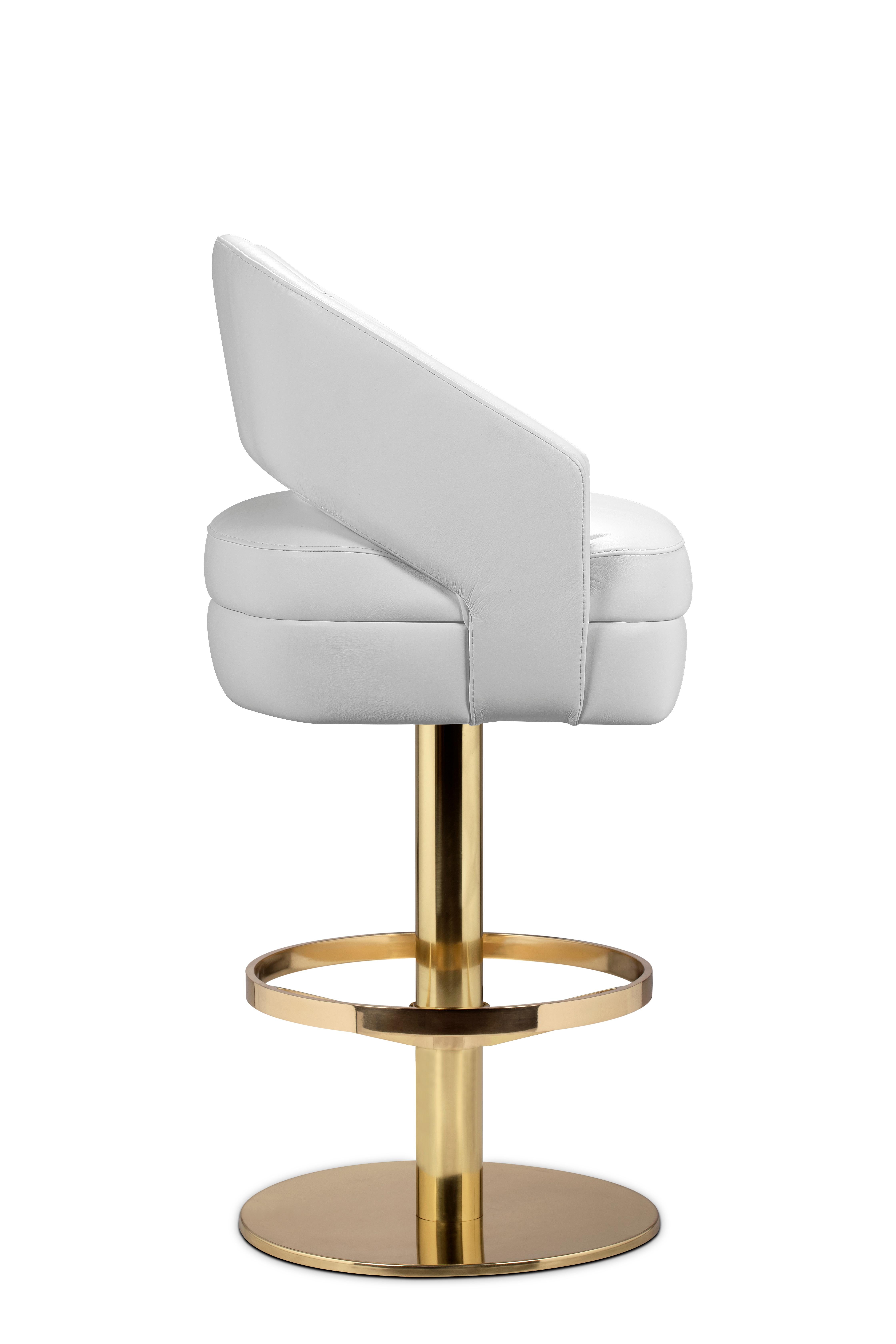 Russel bar chair delve into space age aesthetics, being produced in creamy velvet fabrics mixed with polished brass. The base is round and swivels 360 degrees, providing comfort through the foot rail. Adorn your living room with a sophisticated