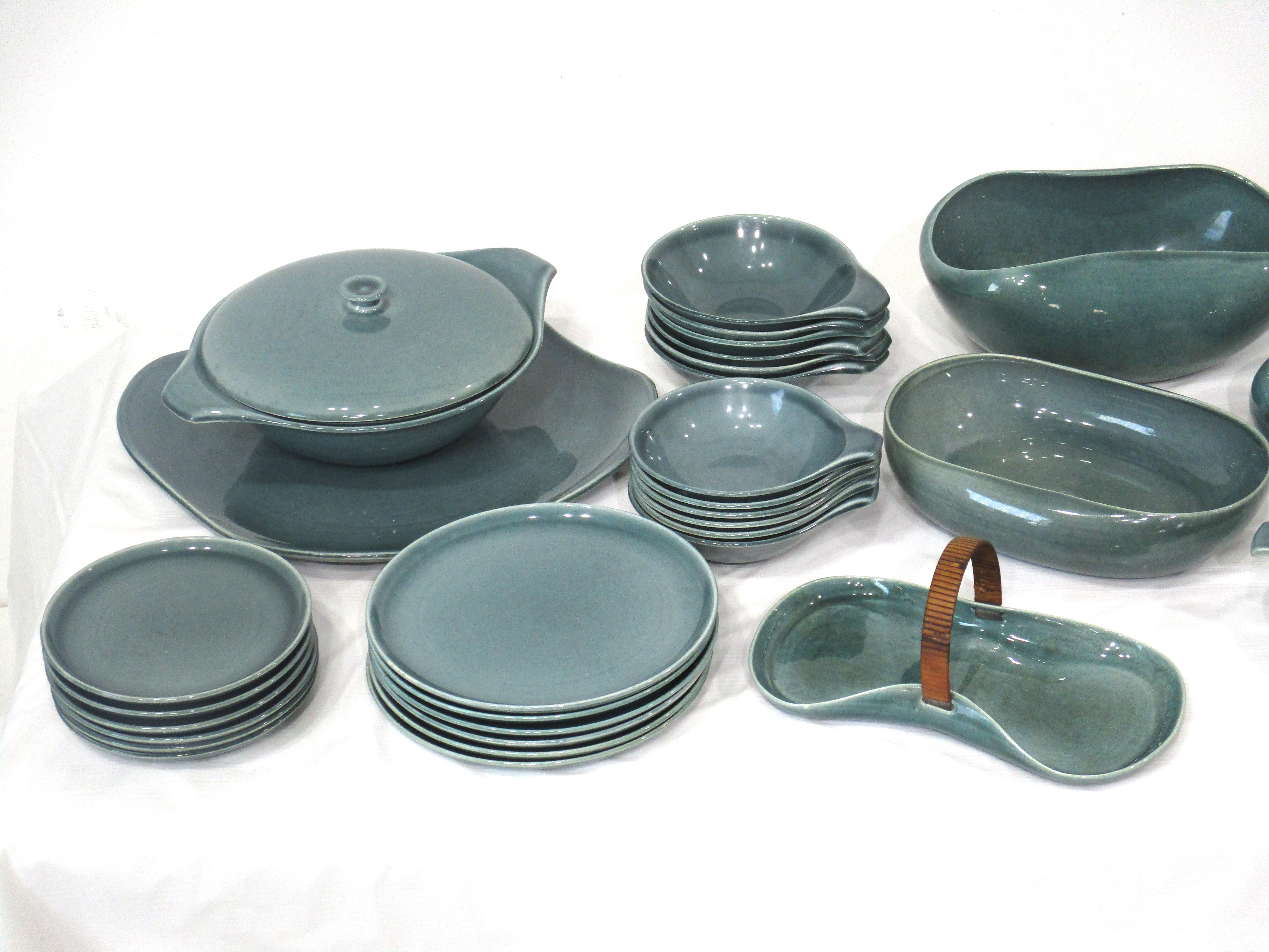 A set of Russel Wright seafoam green dinnerware and serving pieces totaling 42 items . Having 6 place setting of 5 pieces each including 1 dinner , 1 medium , 1 desert plate , 1 soup bowl and 1 salad bowl . A large and medium serving plater , gravy