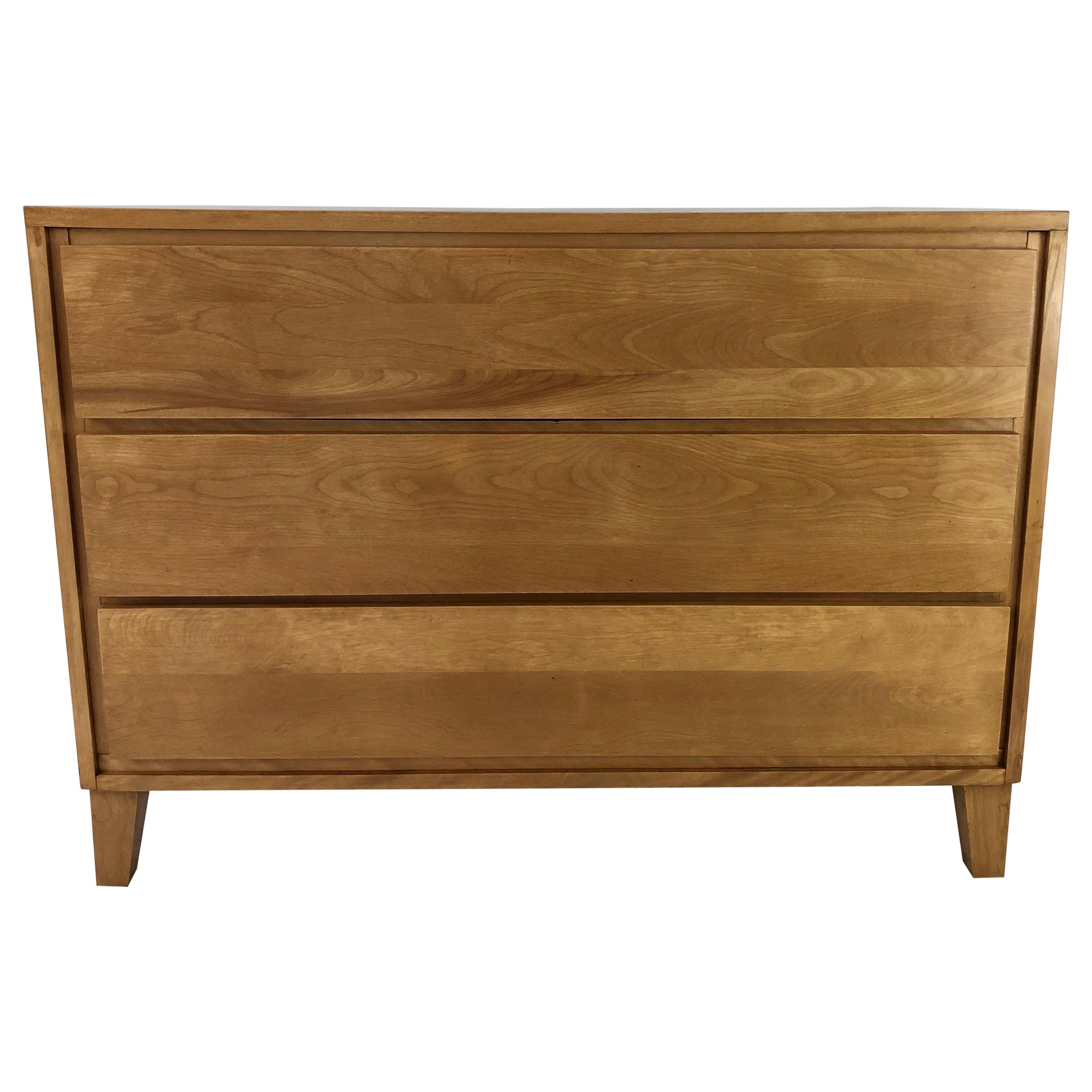 A sleek Mid-Century Modern period chest of drawers, designed by Russel Wright and produced as part of the American Modern line by Conant Ball. The chest is made of solid birch and has three spacious, long handle less drawers. (There is a convenient