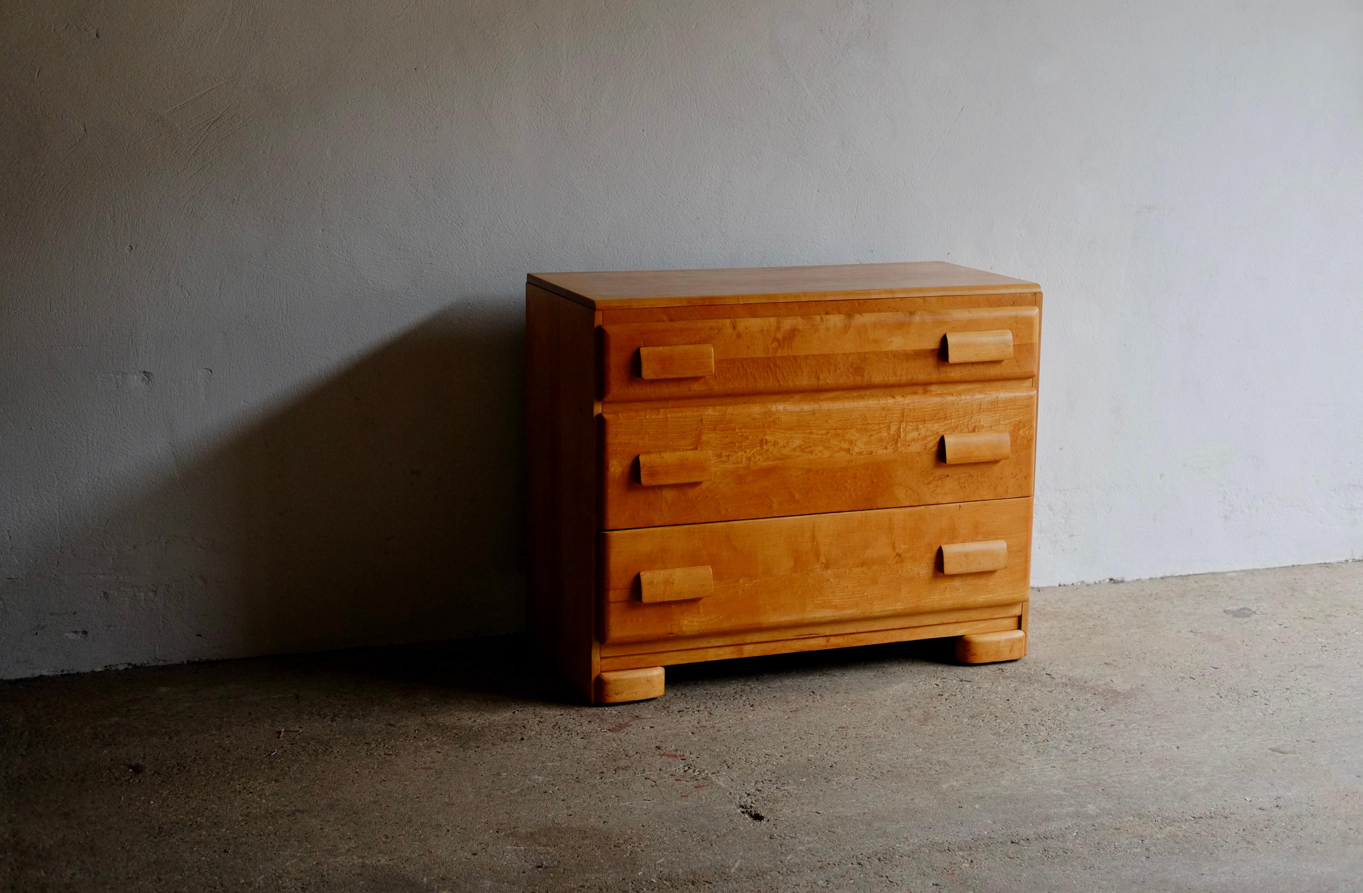 A mid-century honey tone maple chest of drawers in an Art Deco style by Russel Wright and produced by American company Conant Ball. 

In good solid vintage condition with light markings to the top (see photo).