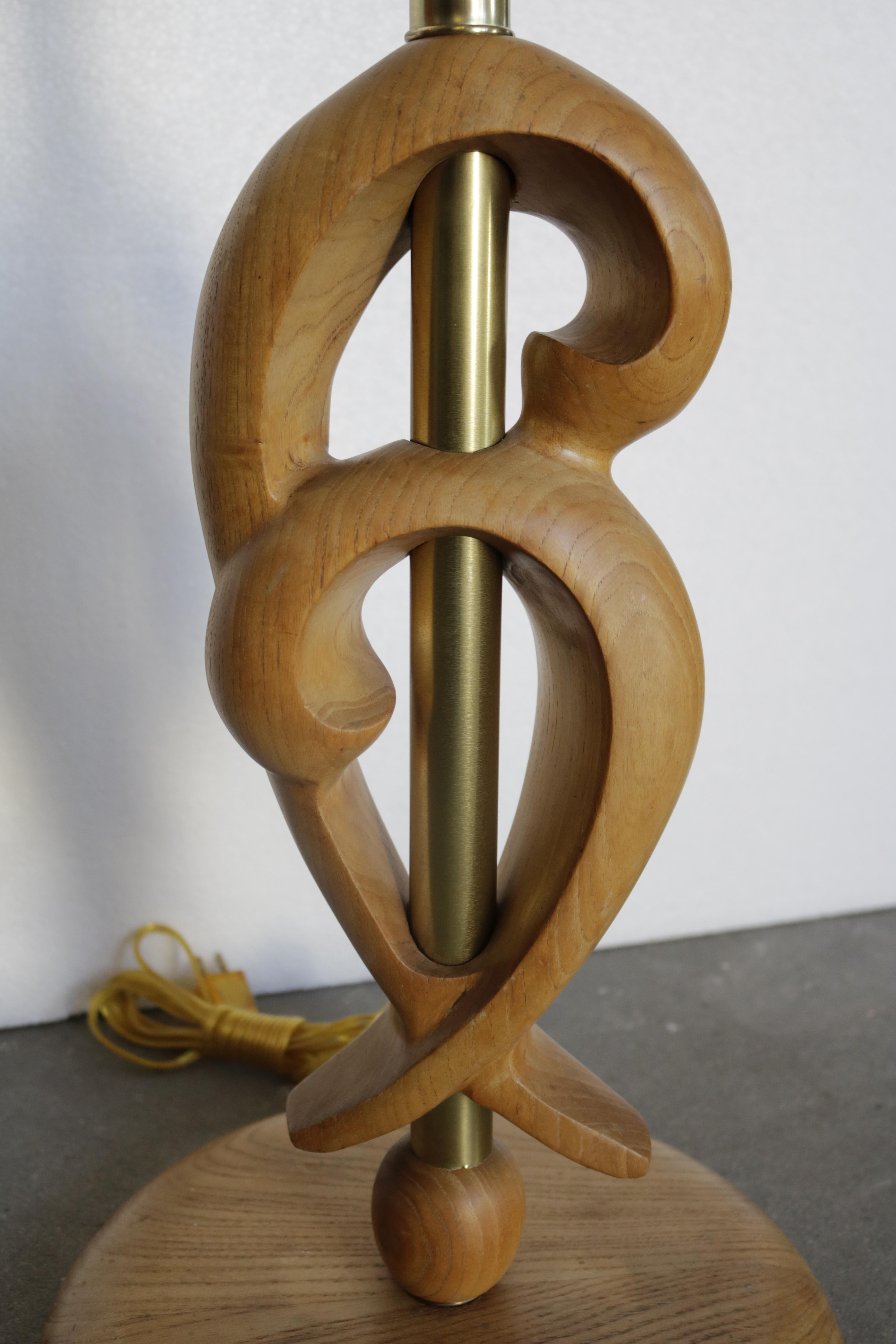 Floor lamp by mid-century designer Russel Wright. The brass stand is wrapped in an oak sculpture in the shape of waves. The base is also oak. The silk shade is a rich brown, almost chocolate color (H13