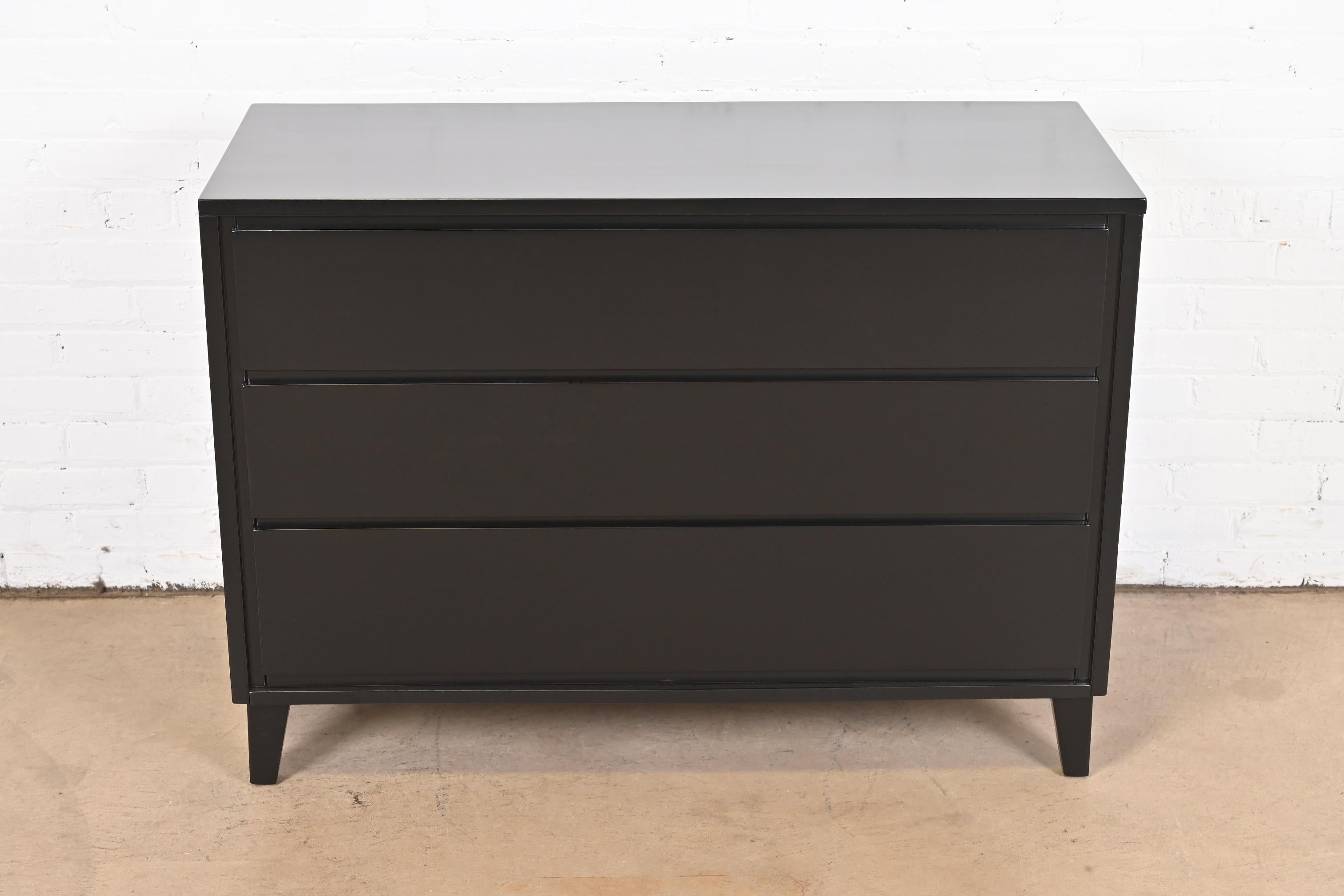 A gorgeous Mid-Century Modern black lacquered three-drawer dresser or chest of drawers

By Russel Wright for Conant Ball 

USA, 1950s

Solid birch, in black lacquered finish.

Measures: 42.38