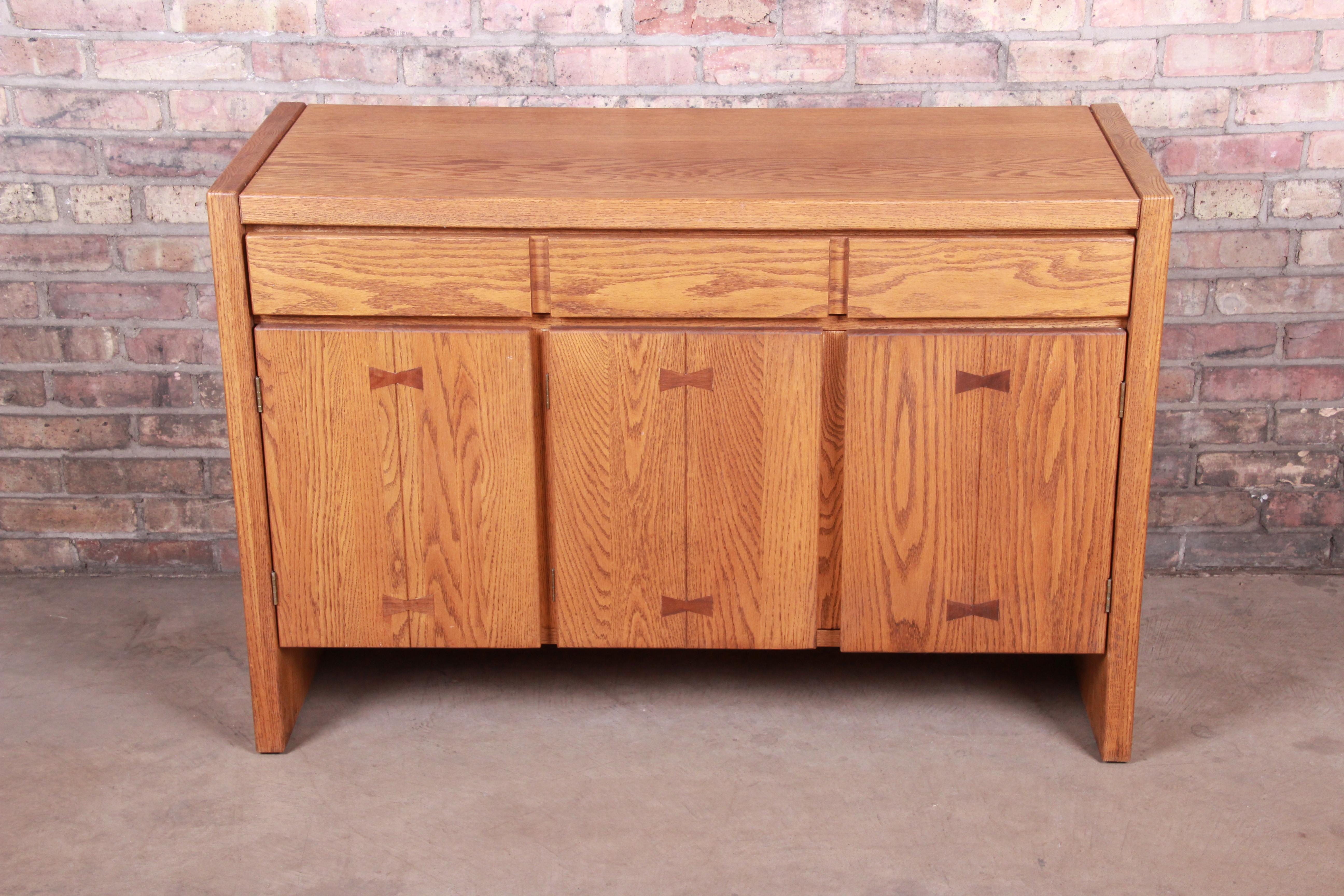 A gorgeous Mid-Century Modern sideboard credenza or bar cabinet

By Russel Wright for Conant Ball

USA, circa 1950s

Oak, with unique inlaid bowtie design.

Measures: 45