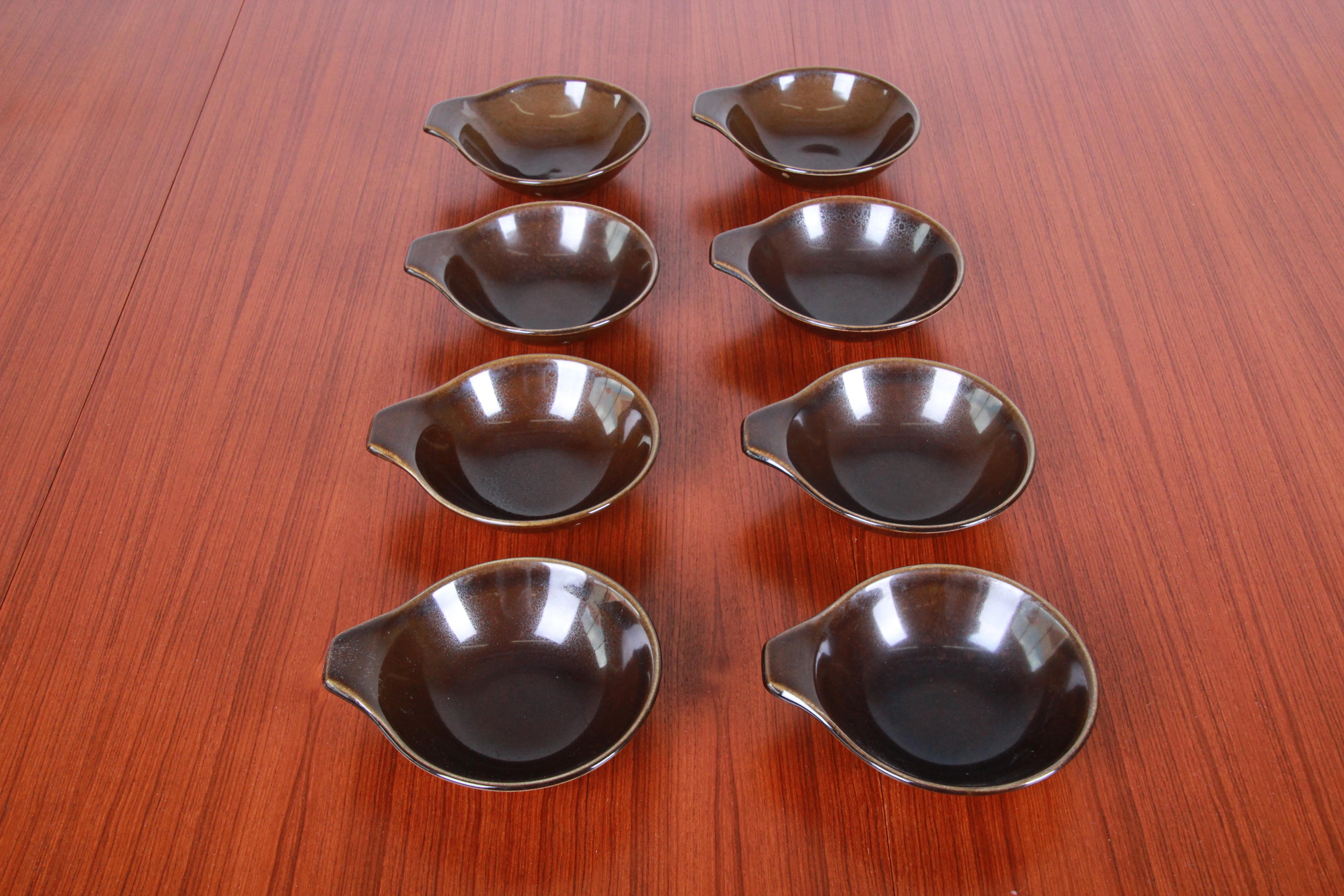 A rare set of 1940s American modern dinnerware designed by Russel Wright for Steubenville Pottery. This set is in the classic glazed brown color. Included is the following: (1) 13.5