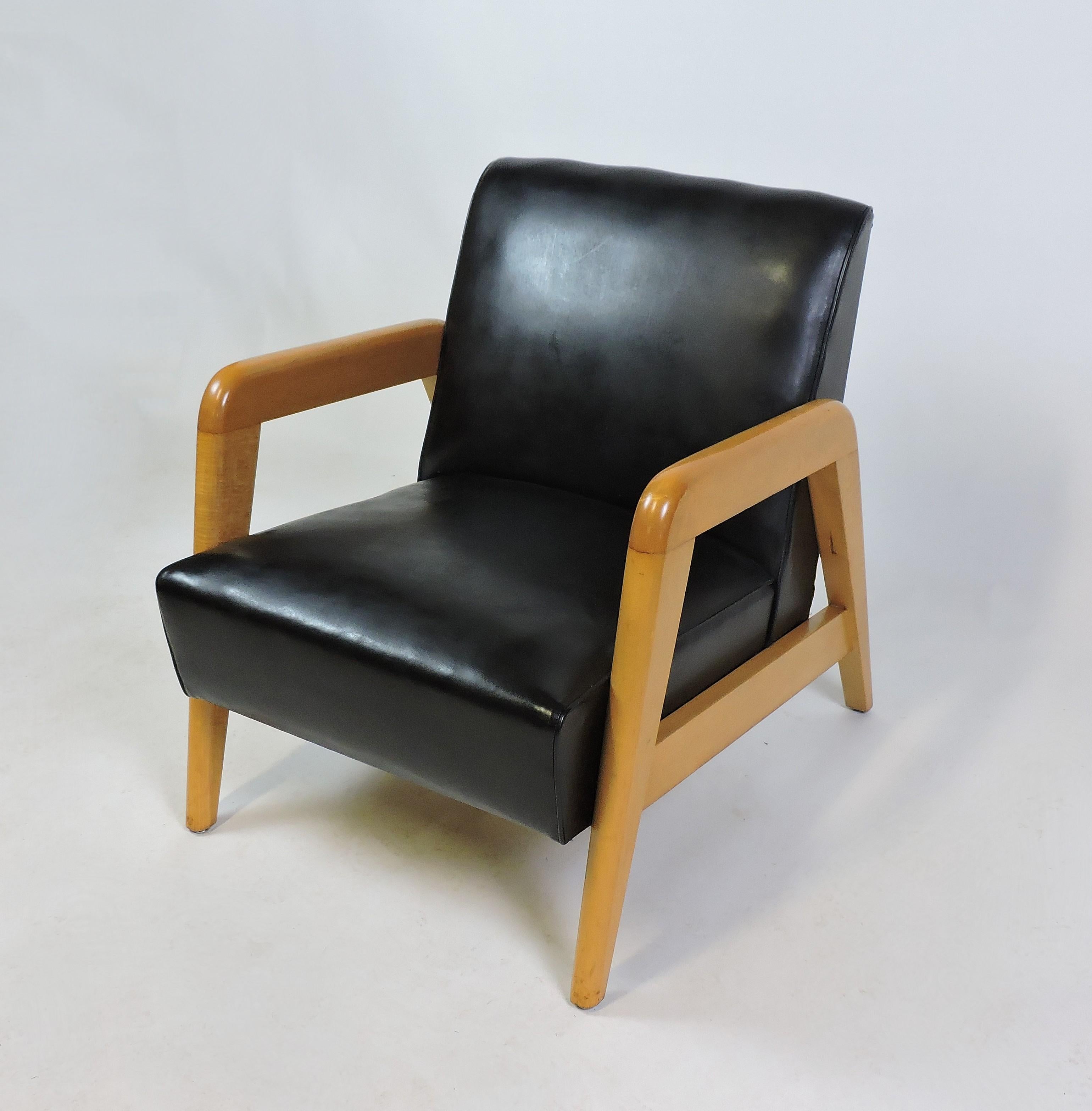 Handsome 1950s armchair chair designed by noted American Modern designer, Russel Wright. This chair has a solid maple wood frame and the original black vinyl upholstery. A very comfortable and well made chair.