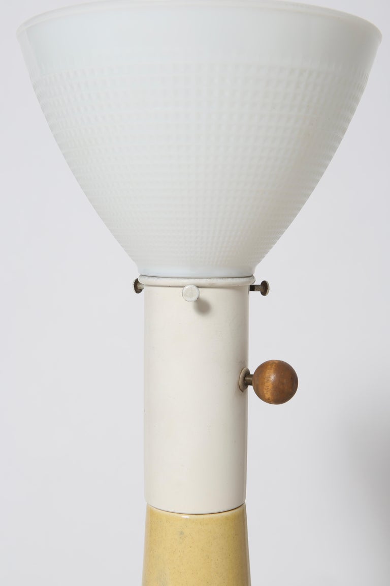 Grand scale ceramic table lamps designed by Russel Wright for Fairmont. Wonderful soft yellow glaze with brass ring detail and Wright’s signature wooden knob. Lamps are sold with original milk glass diffusers, however there are no shades. The