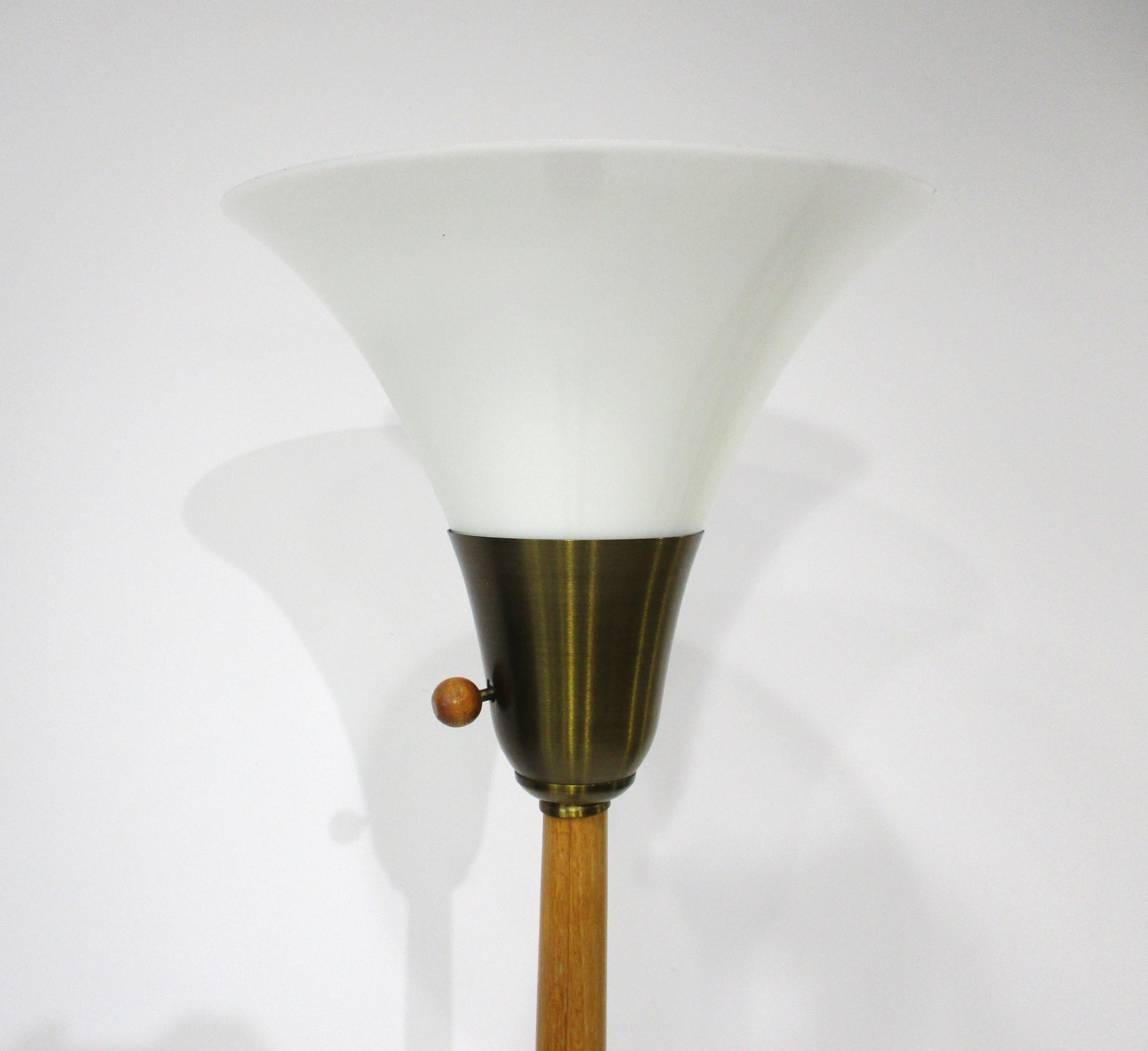 Una lampada da terra di ottima fattura con paralume a imbuto in vetro lattiginoso, interruttore a sfera in legno rotondo, supporto del paralume in ottone filato e base montata su un'asta in rovere pettinato. Disegnato da Russel Wright, che con le