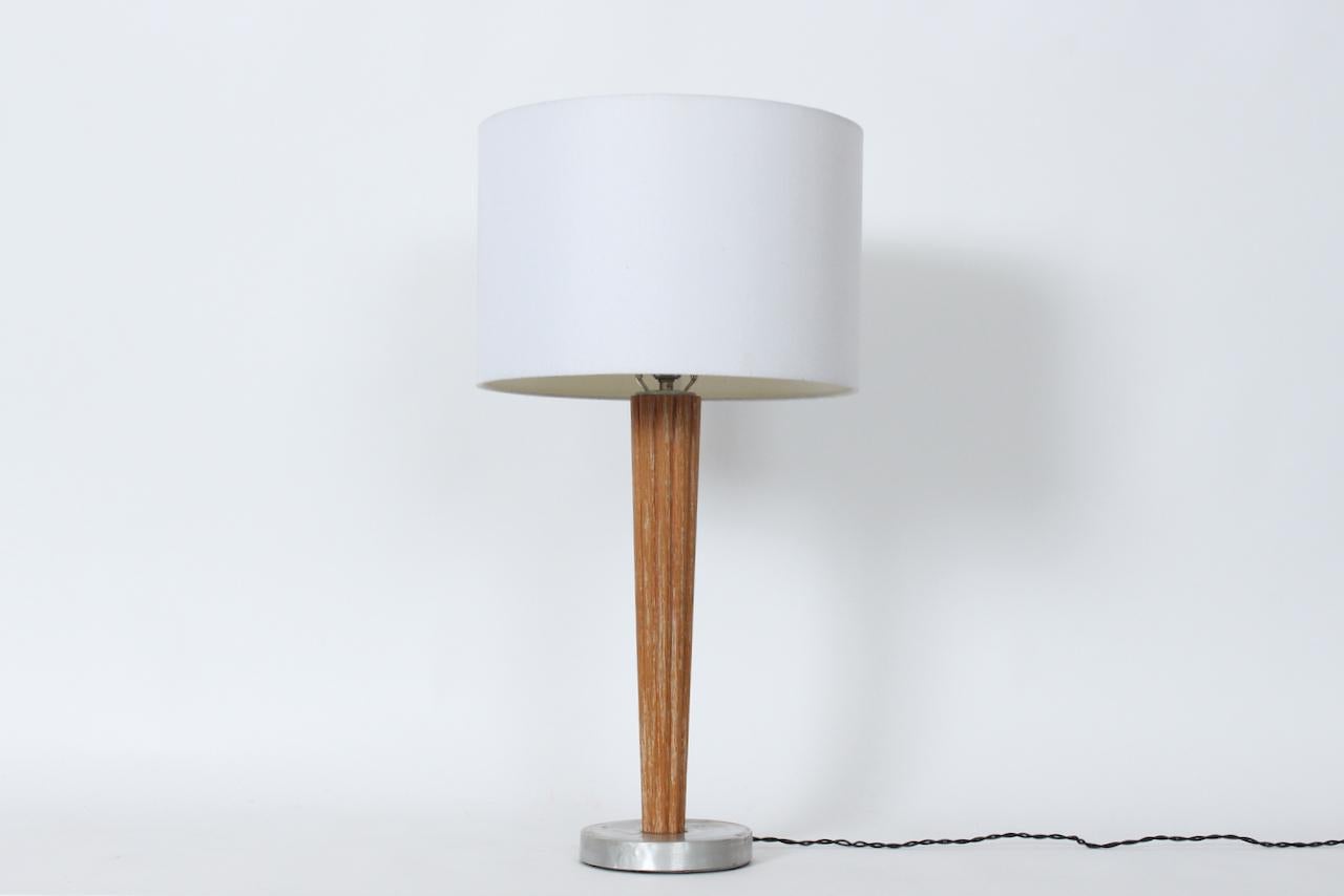 Lampada da tavolo in stile Russel Wright in Oak cerato e alluminio filato, anni '40.  Caratterizzato da una colonna in Oak Oak tornita, affusolata e con nervature morbide, che poggia su una base circolare rivestita in alluminio. Ingombro ridotto. Il