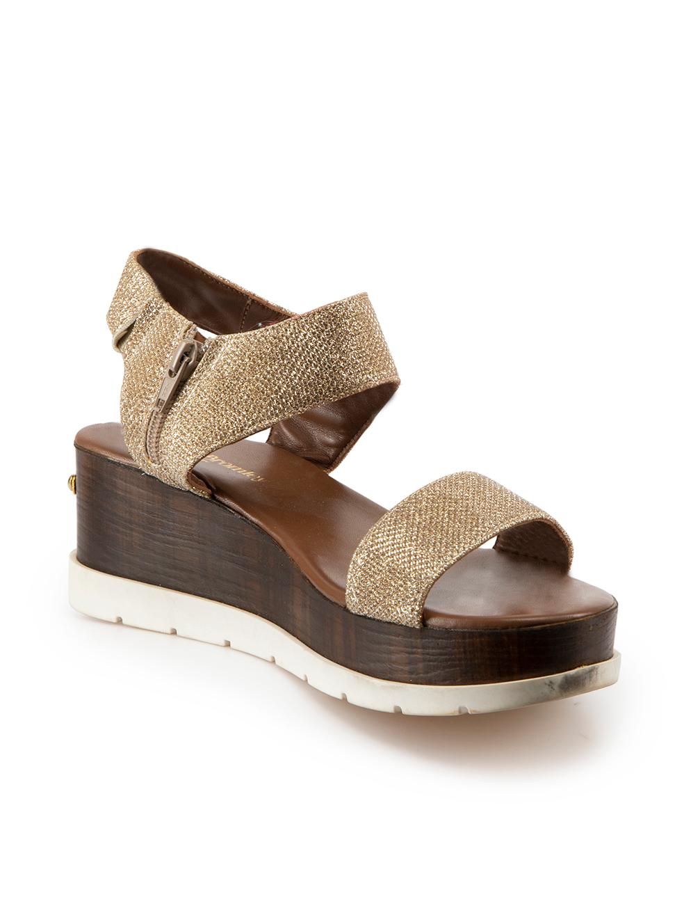 CONDITION is Very good. Minimal wear to sandals is evident. Minimal wear to the rubber soles of both shoes with discoloured marks on this used Russell & Bromley designer resale item. 
 
Details
Gold
Glitter
Slide sandals
Open toe
Platform wooden
