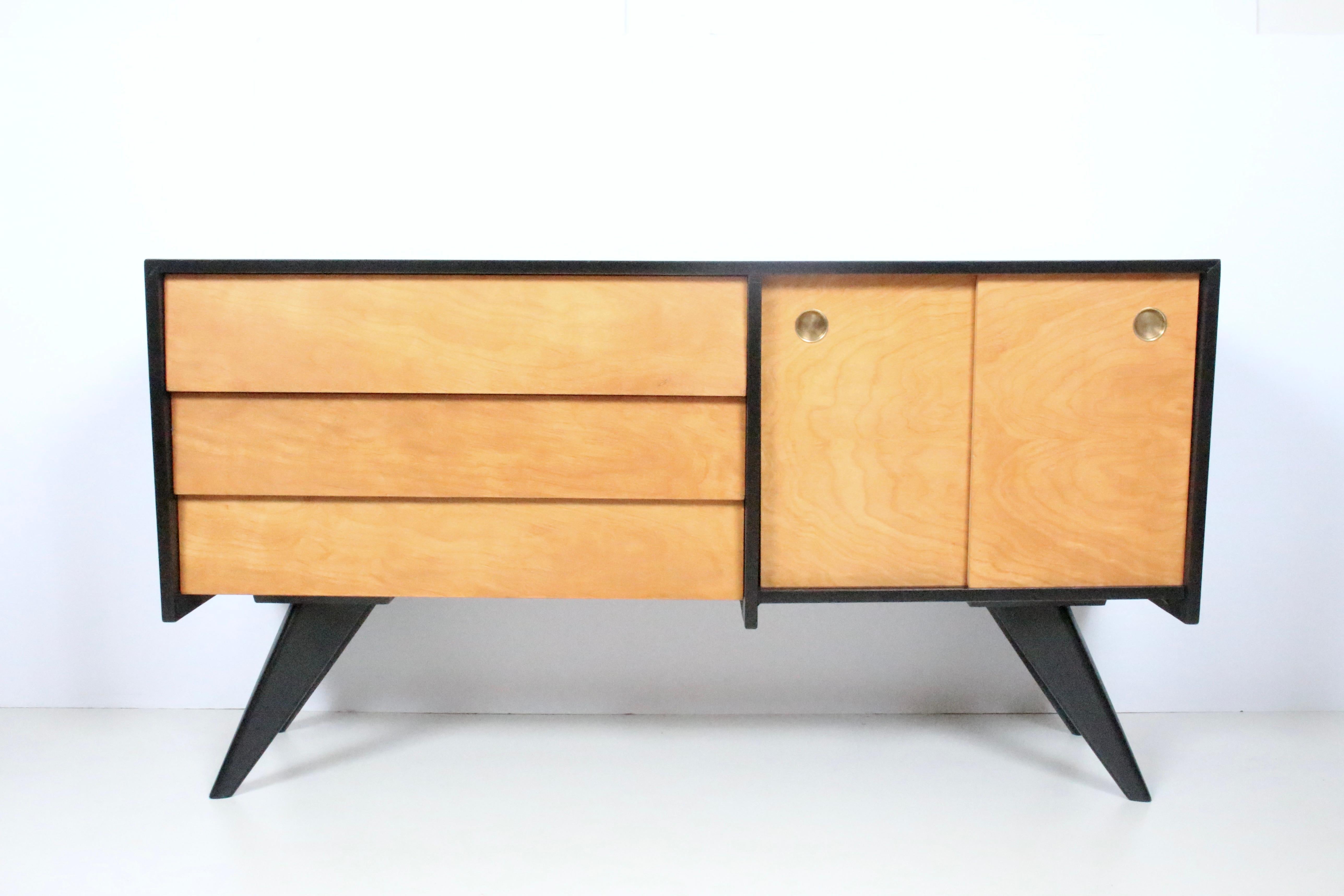 1952 designed Russell Spanner Catalina Series Server, Cabinet, Dresser for Ruspan of Toronto, Canada.  Featuring a rectangular black lacquered Maple form, on 4 splayed legs, 2 sliding doors with black interior, and 3 overlapping drawers.  Solid.