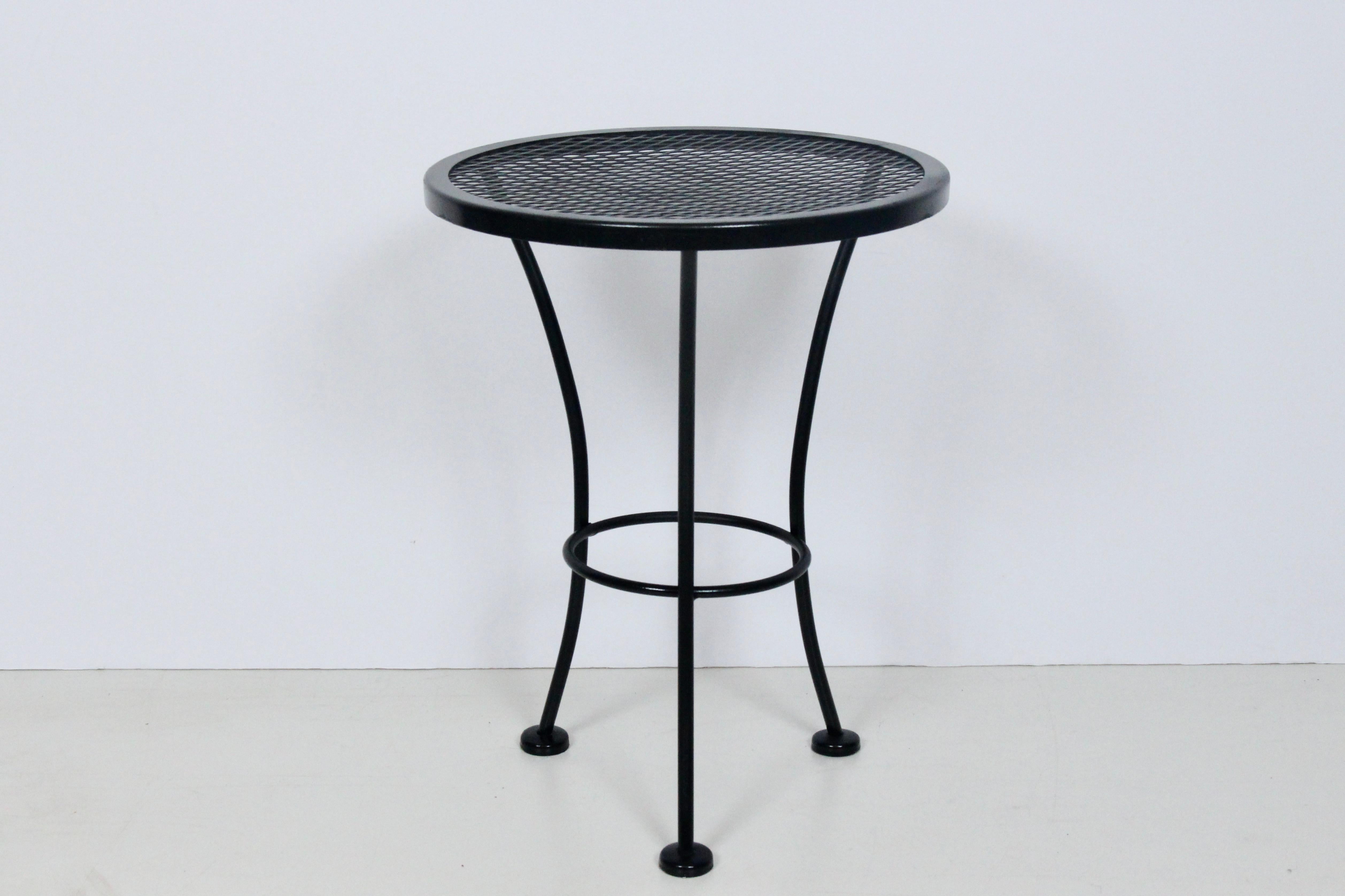 Original Russell Woodard Black Wrought Iron and Wire Mesh Occasional Table.  Featuring a High Black Gloss enameled three legged reinforced framework with sturdy circular, wire Mesh surface and capped feet.  Indoor / Outdoor. Versatile. 1950's.