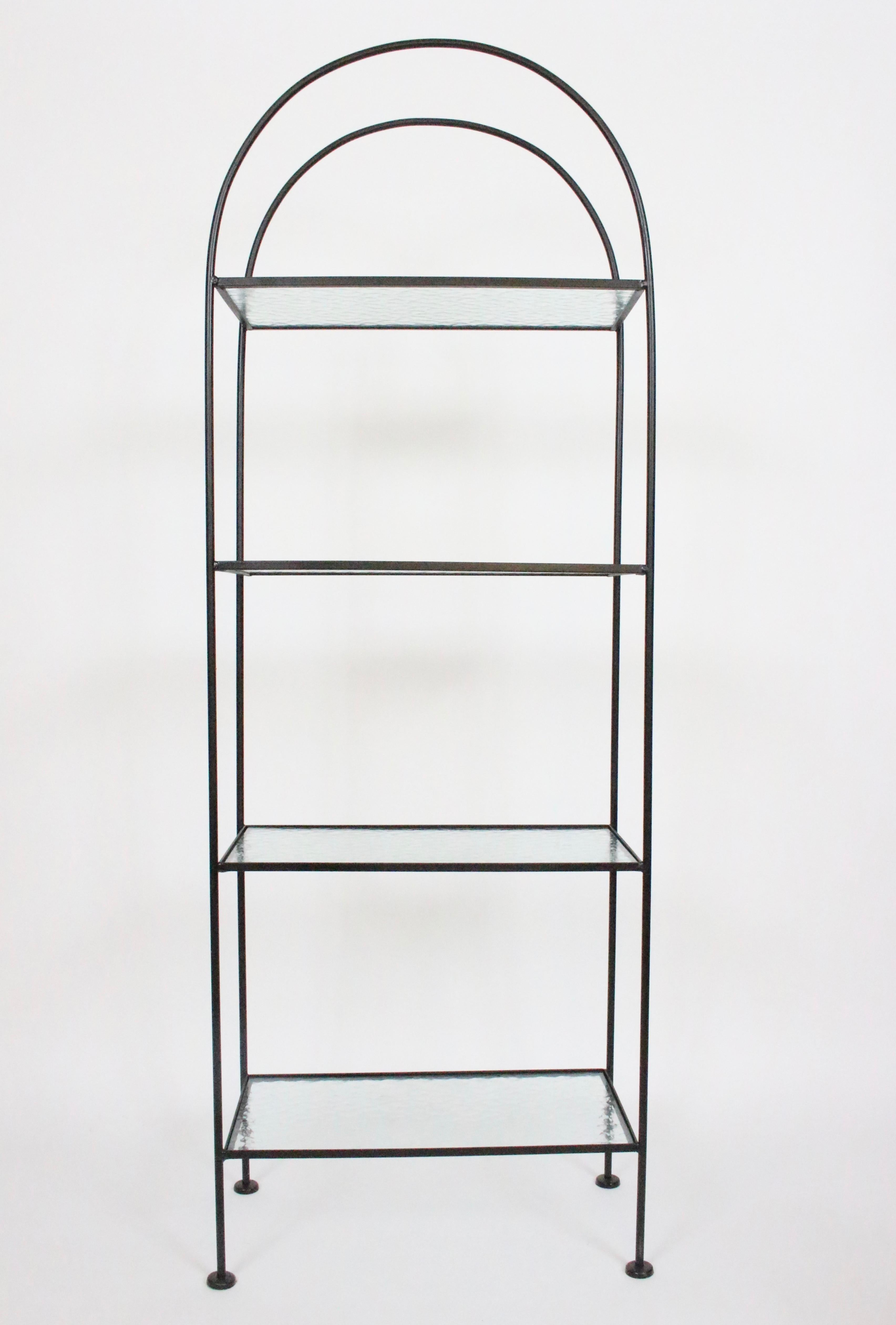 Russell Woodard four tier black iron étagère with original water glass shelves, circa 1960. Featuring a rounded top with sturdy black enameled framework, 4 original rippled tempered .25