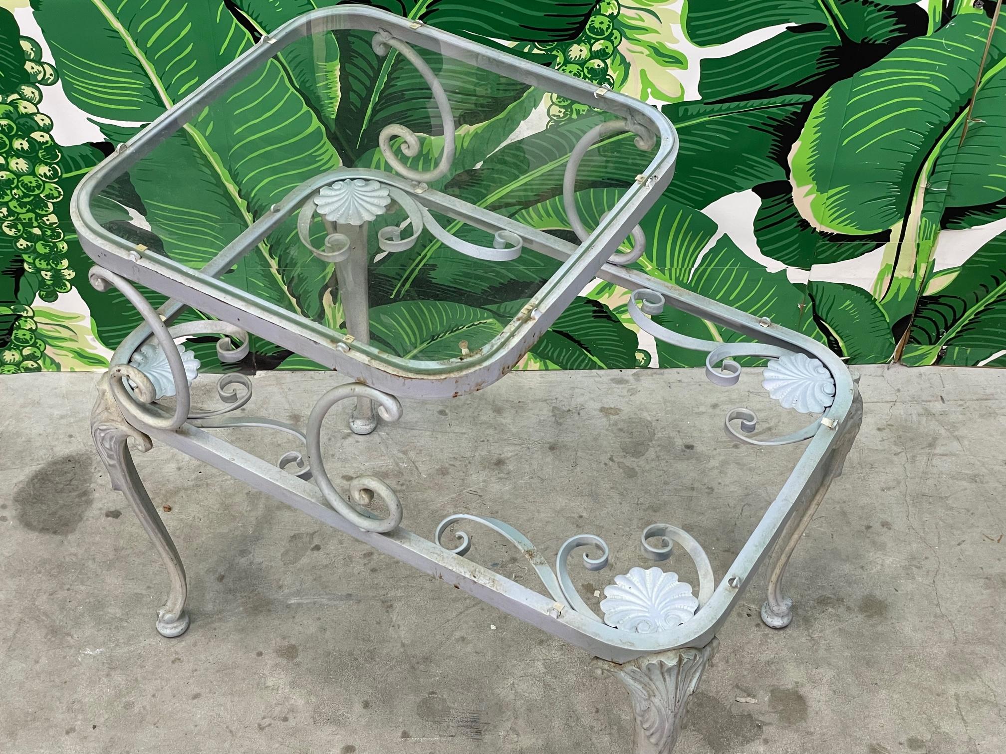 Midcentury wrought iron step table by Russell Woodard features floral detailing and two shelves. Lower shelf is missing glass. Good vintage condition with imperfections consistent with age, see photos for condition details. We also have the matching