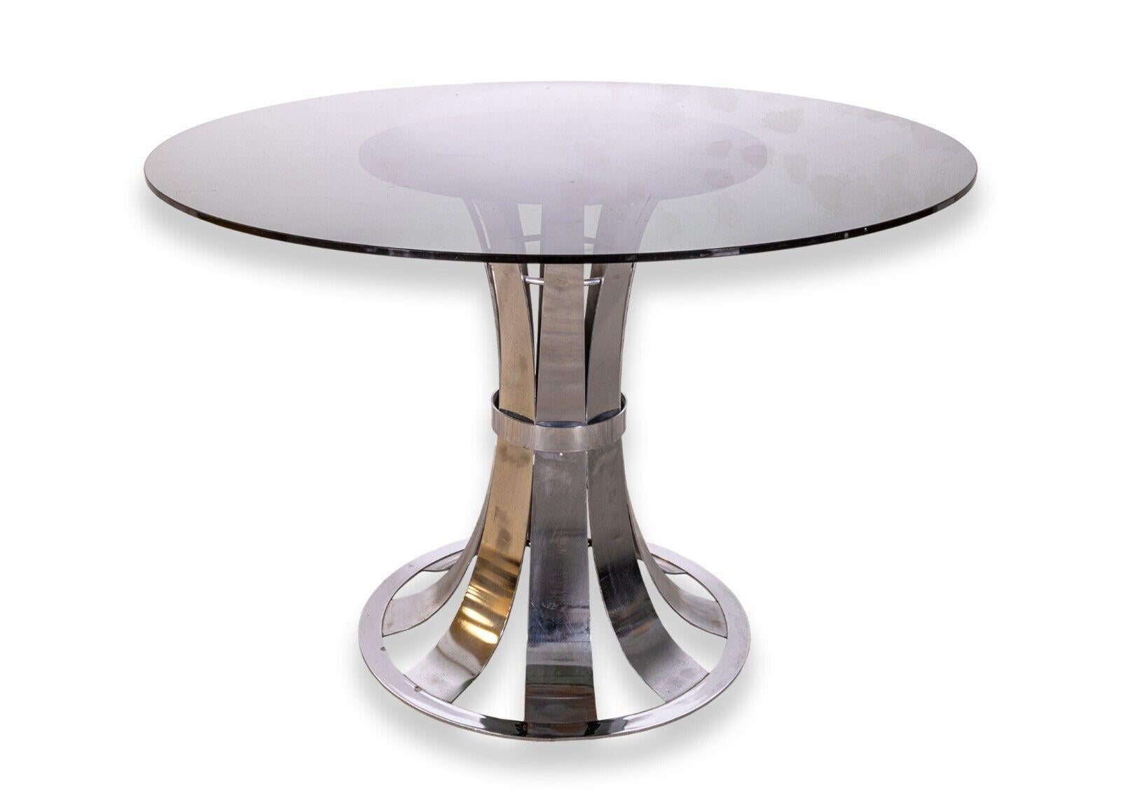 A Russell Woodard polished aluminum dinette set. This is a fantastic mid century modern set of rare Russell Woodard furniture. Known for his patio furniture, this Woodard dinette set is meant for indoor use. This set includes a round, smoked glass