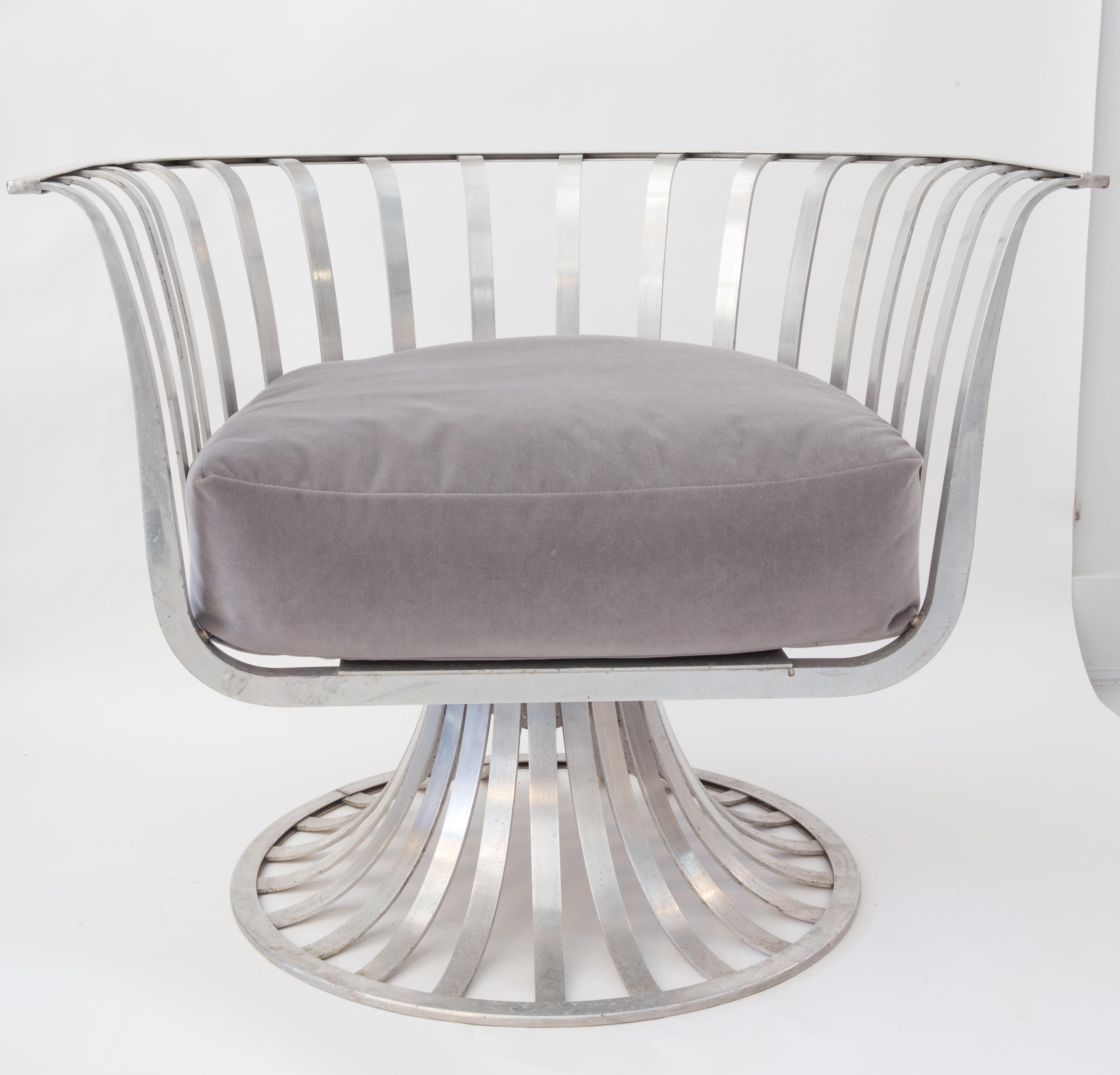 Russell Woodard midcentury pair of polished aluminum swivel armchairs. This pair of chairs was Designed by Herbert Saiger for Russell Woodard. The chairs are in great condition, could be polished to high finish. There is a separation to one weld on