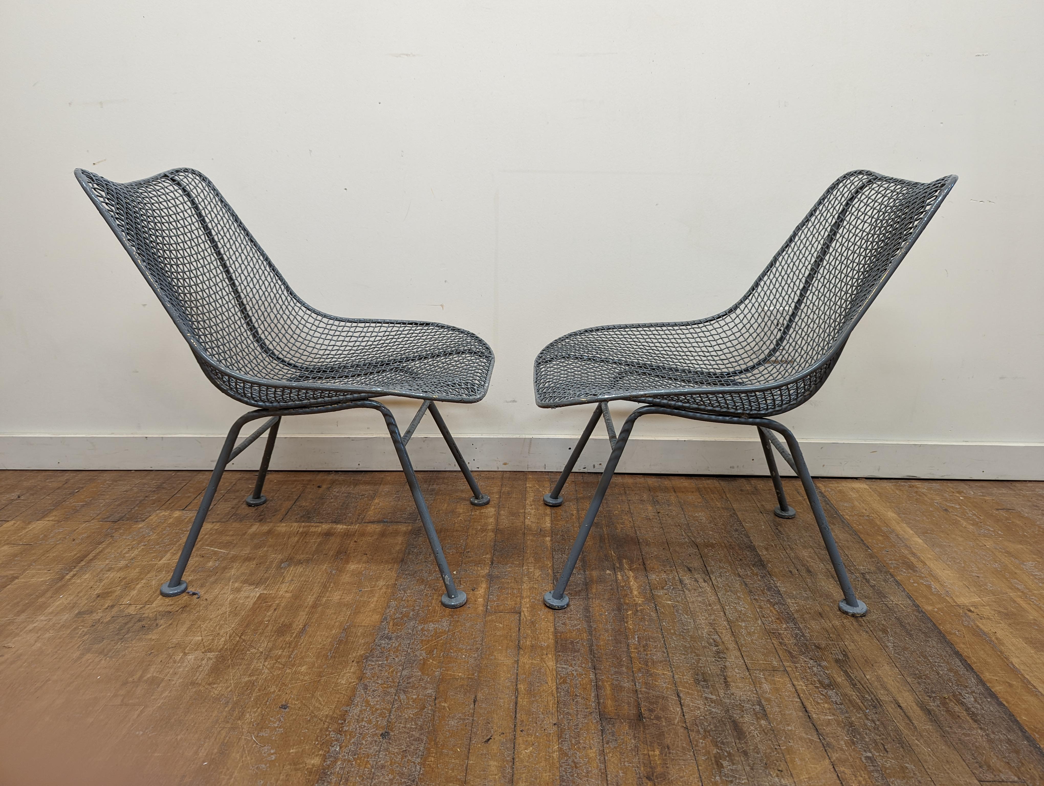 Pair of sculptura chairs by Russell Woodard. Iron mess on frame patio chairs designed for outdoor use but many use them inside. Painted gray by previous owner. In good condition. Classic Mid-Century Modern.