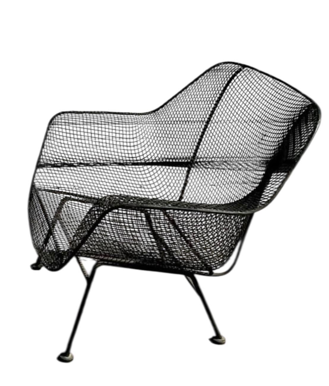 Der Russell Woodard Sculptra Lounge Chair zeigt eine skulpturale Silhouette aus schwarzem Schmiedeeisengeflecht. Der Stuhl verfügt über eine breite, geschwungene Sitzfläche und eine sanft geneigte Rückenlehne mit integrierten Armlehnen, die ihm eine