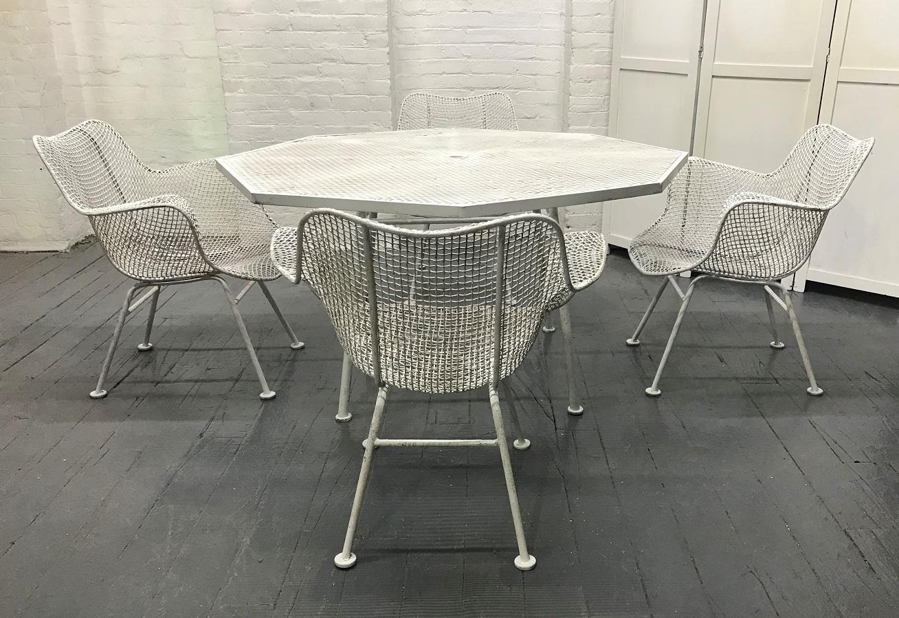 Russell Woodard patio set. The set has a mesh pattern, four armchairs and matching octagonal shaped table.
Measures: Table 52 W x 52 D x 25.5 H.
Chairs 26.25 W x 24 D x 28.25 H.
