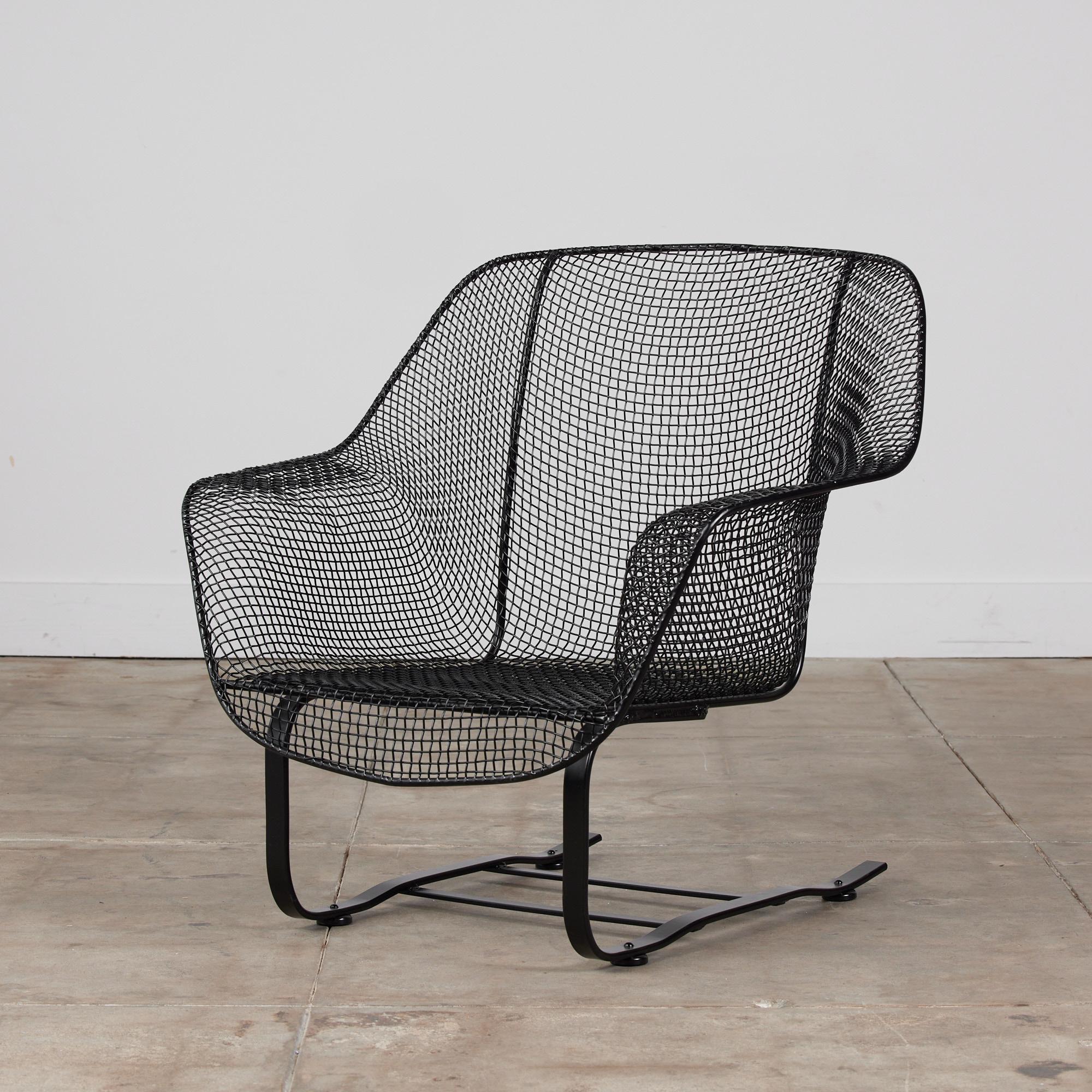 Outdoor rocking chair by Russell Woodard for Woodard Furniture, c.1950s. The rocking chair is from Woodard’s “Sculptura” line designed in 1956. The chair has a molded mesh frame that sits atop two wrought iron spring legs. The chair has been