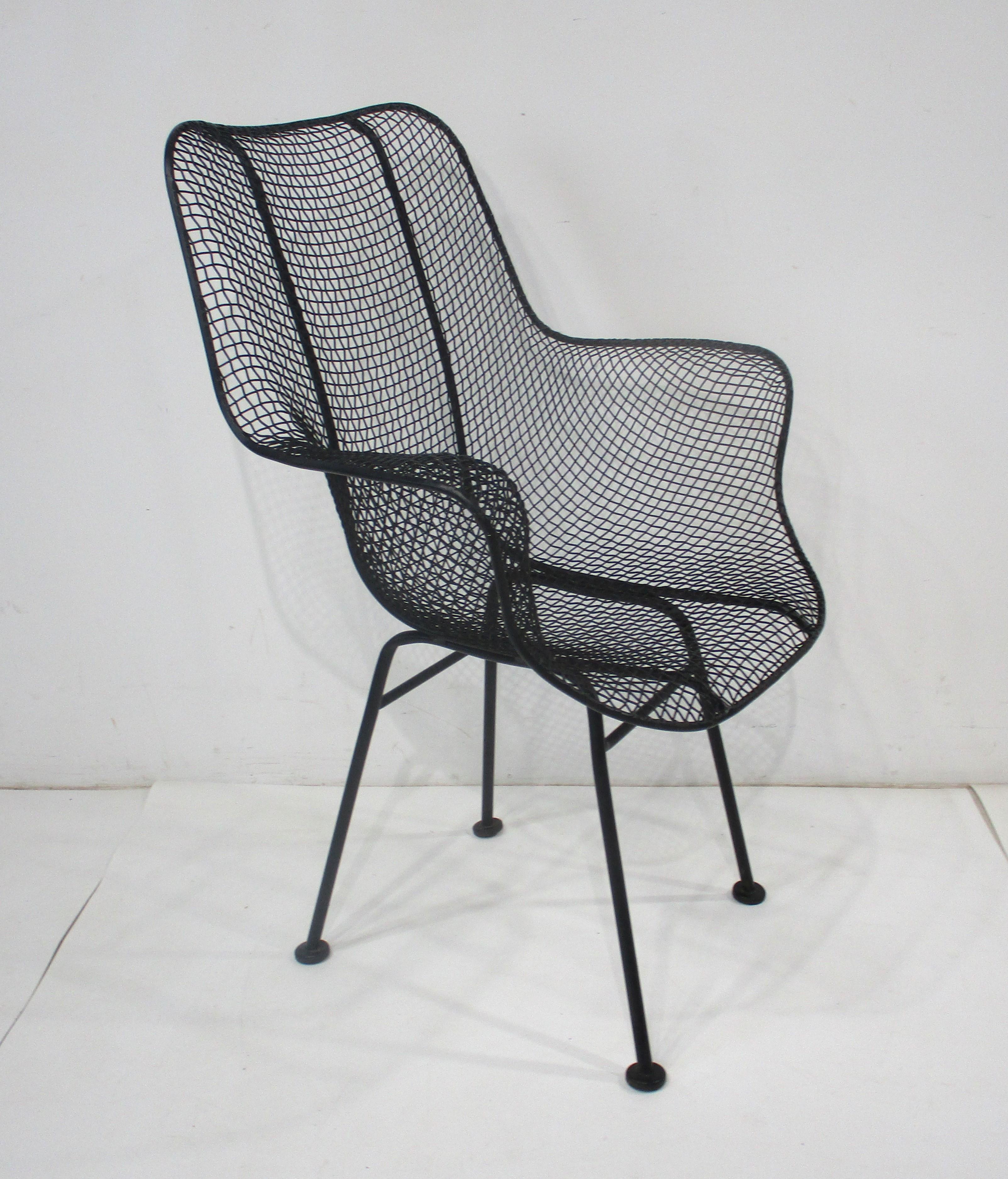 A wire and iron molded and welded Sculptura armchair in the style of Eames with foot pads and in a satin black finish. Great for a three seasons room, deck, porch or that cozy garden, super comfortable manufactured by the Woodard Furniture Company