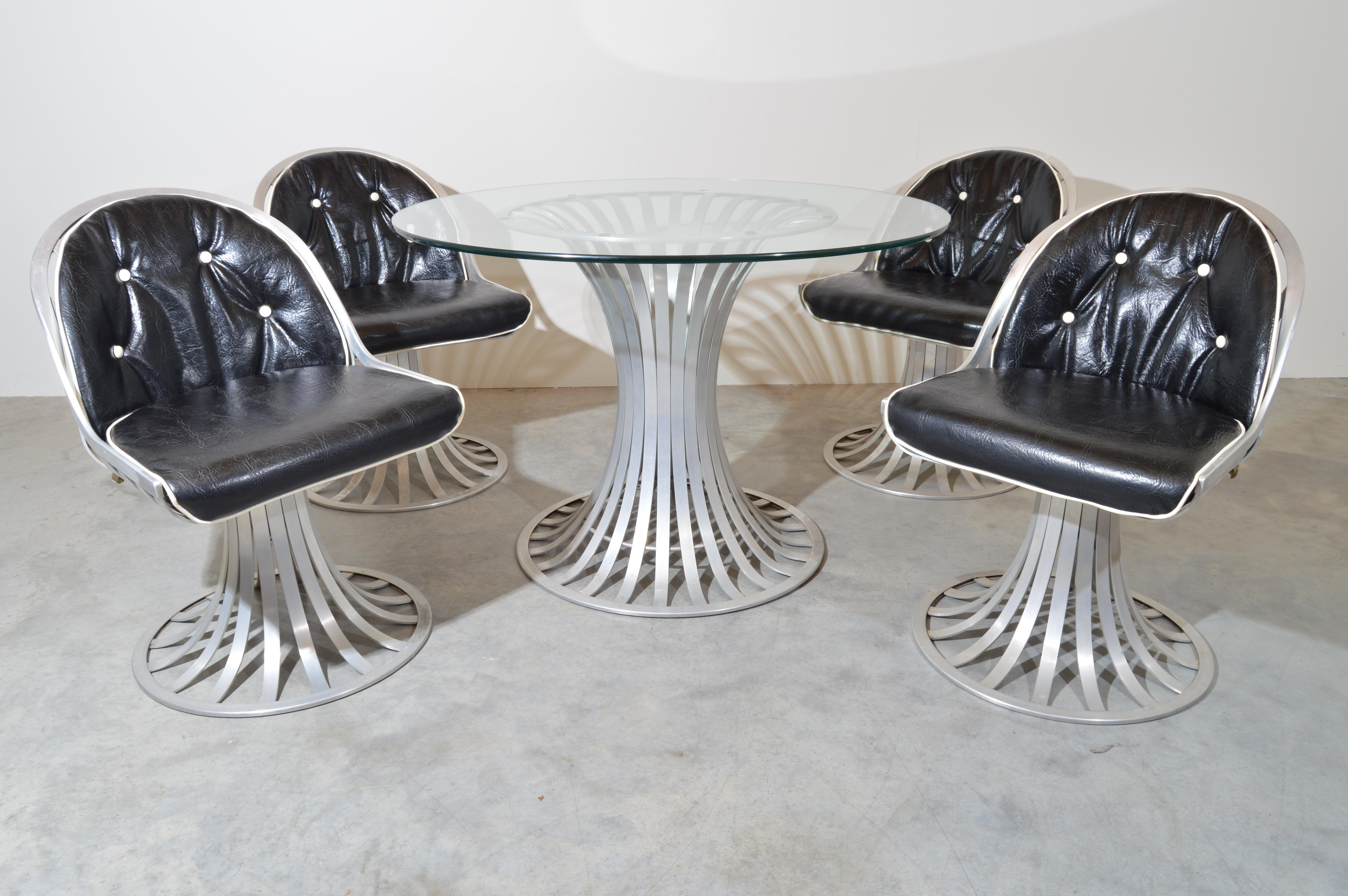 Mid-century sculptural aluminum dinette set having clear round glass top and vinyl seats designed by Russell Woodard for Lee L. Woodard & Sons. The table measures 28.5 x 42” height & diameter. 
The chairs are 31 x 21.25 x 25” HWD SH 18”
The set is