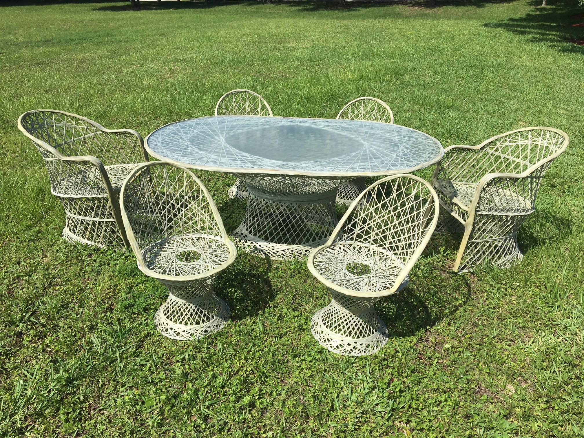 Midcentury spun fiberglass dining set by Russell Woodard in rare light green color. Features two armchairs, four side chairs, and large oval table with original glass top. Good vintage condition with slight discoloration consistent with age (see