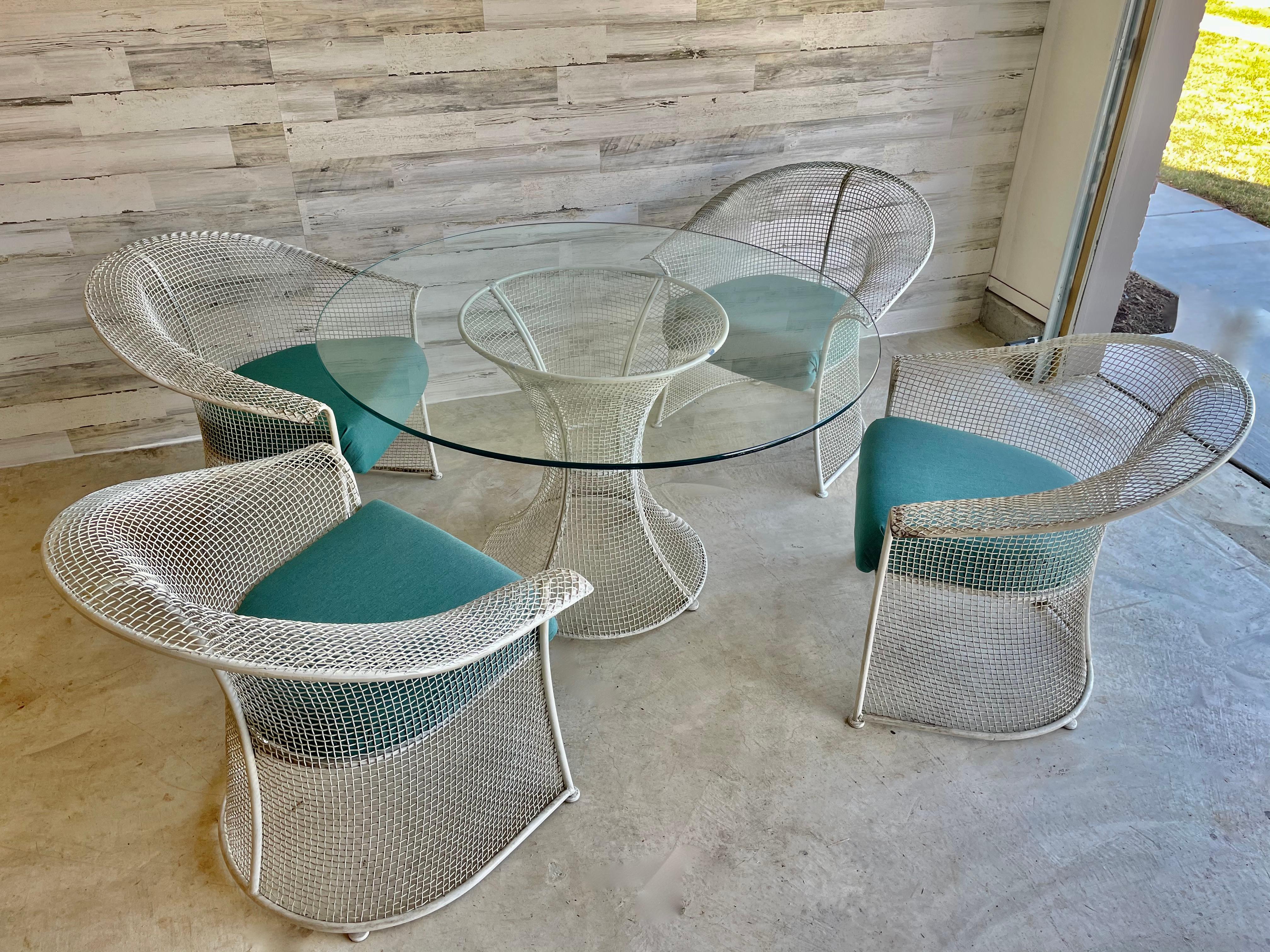 Russell woodard wire formed patio dining set. Newly reupholstered in a teal sunbrella fabric. This set has a nice patina on it. Ready for use or can be powder coated if desired. 

Table dimensions: 48 L x 48 W x 28.5 H
Each chair: 29 L x 26 D x
