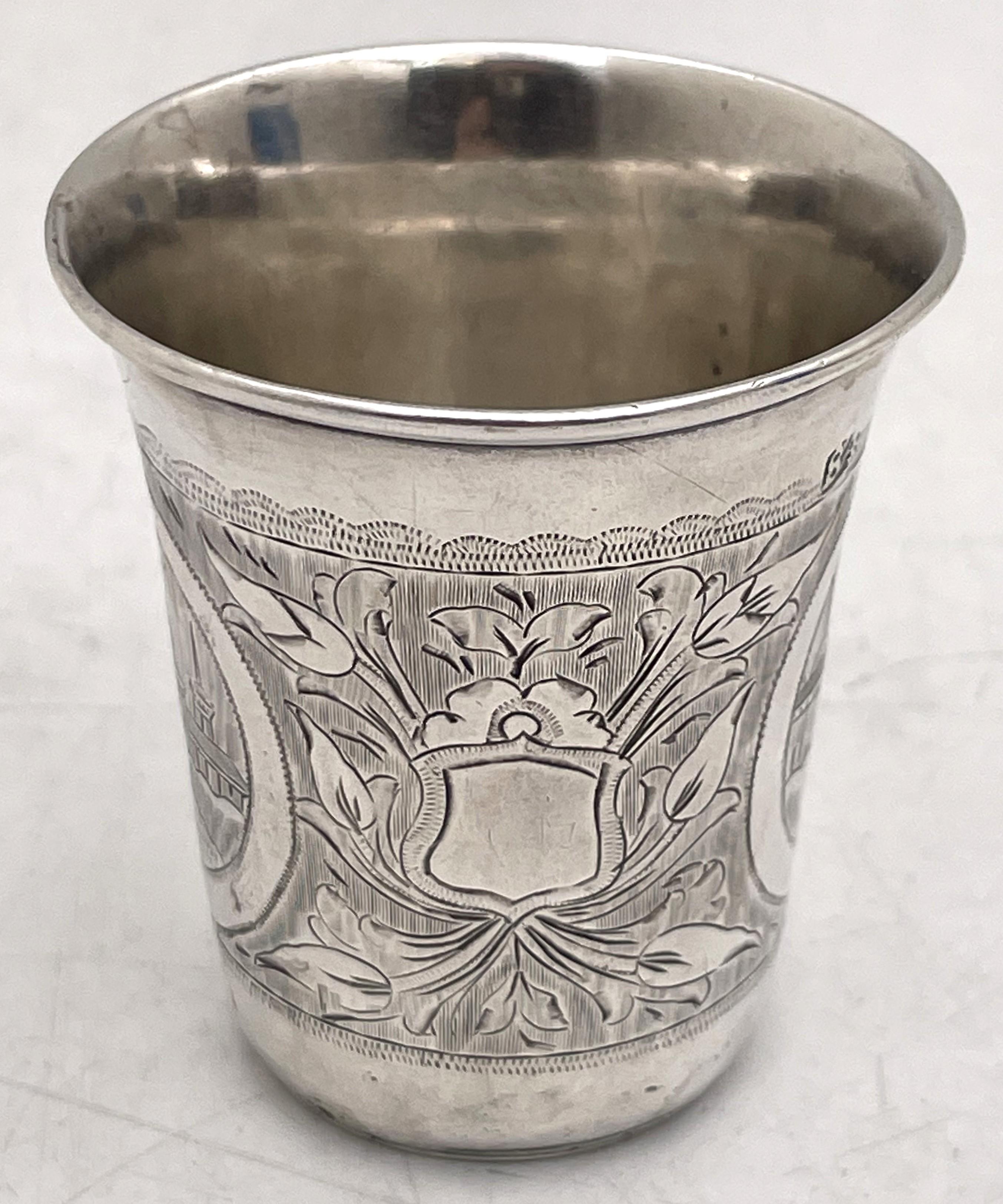 Russian 0.84 silver Kiddush cup from the mid- to late 19th century (possibly 1869?)  showcasing stylized natural and architectural motifs. It measures 2 1/3'' in height by 2 1/8'' in diameter at the top and bear hallmarks as shown. 

Please feel