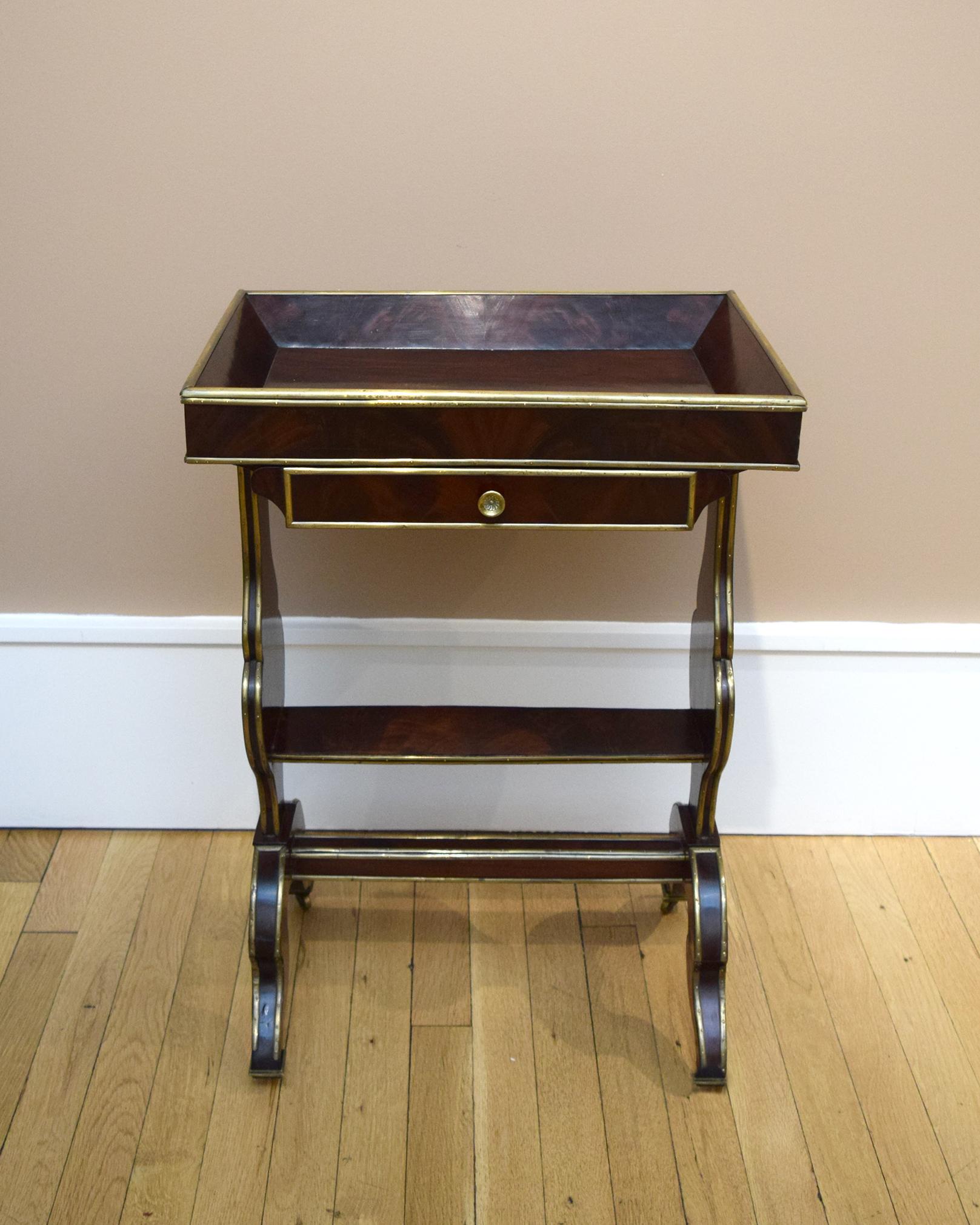 Every contour and plane of this exquisite tray-top, mahogany table on wheels is outlined with glinting brass stringing — a hallmark of Russian cabinetry in the late 18th and early 19th centuries. The form, however, is derived from the furniture then