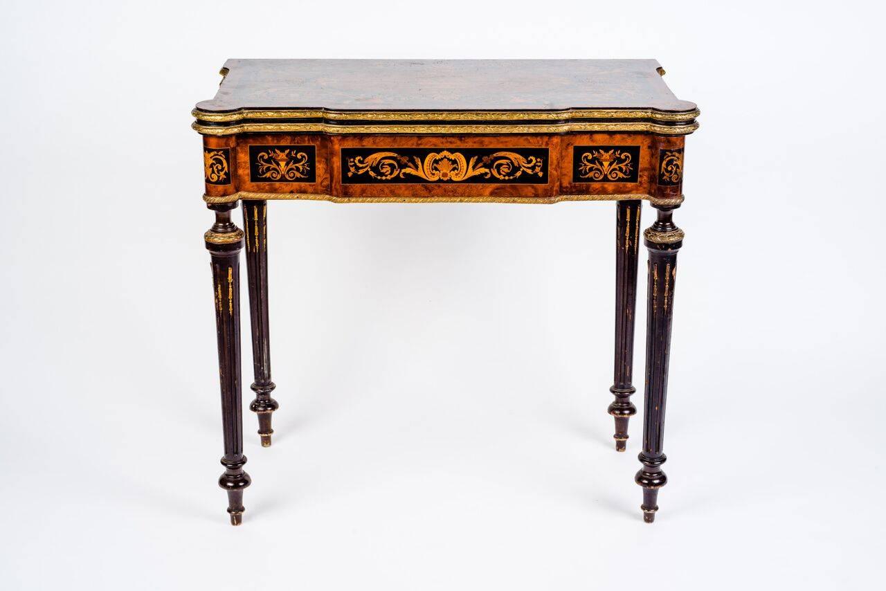 A rare and elegant marquetry Russian game table.
 With central floral marquetry motif and gilt bronze-mounted. Opening to reveal inset green based playing surface with marquetry inlay in birchwood and exotic woods.

Measures in cm: 87 x 82 x