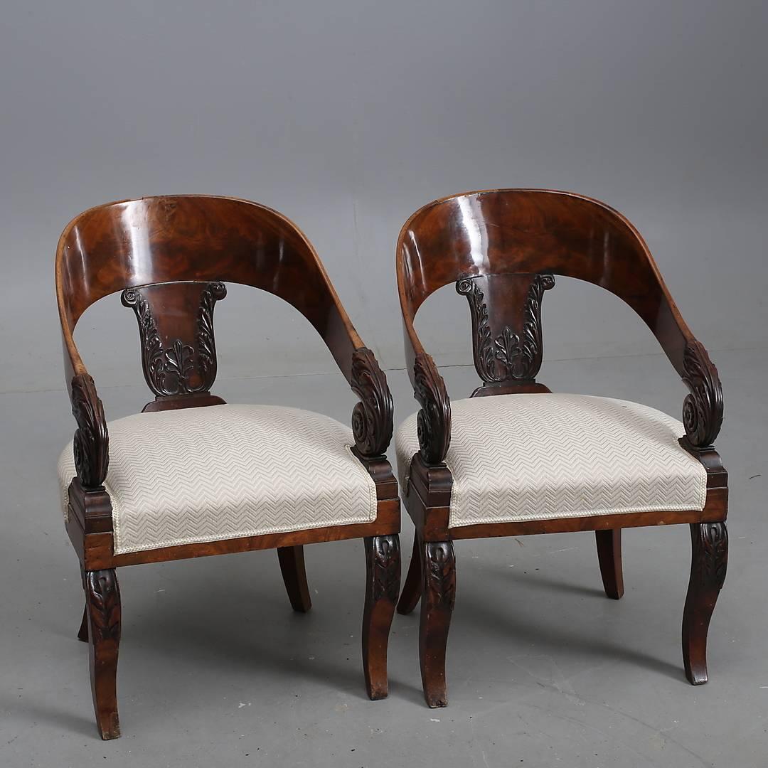 Russian armchairs in mahogany with a nicely curved back, carved acanthus decorations and with armrests ending in cornucopias.